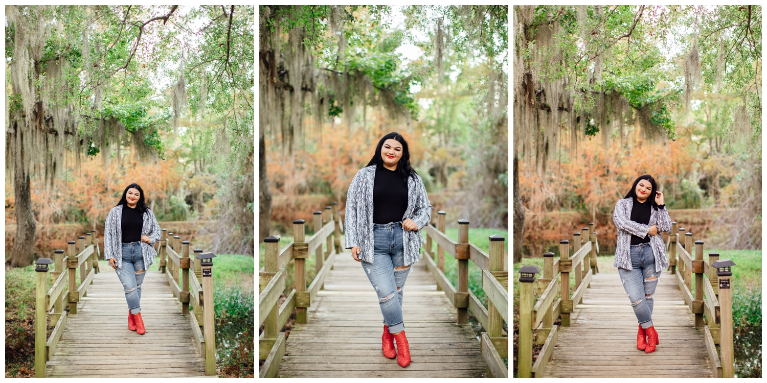 girl in denim jeans and red sequins boots standing on bridge under mossy trees at CyHope