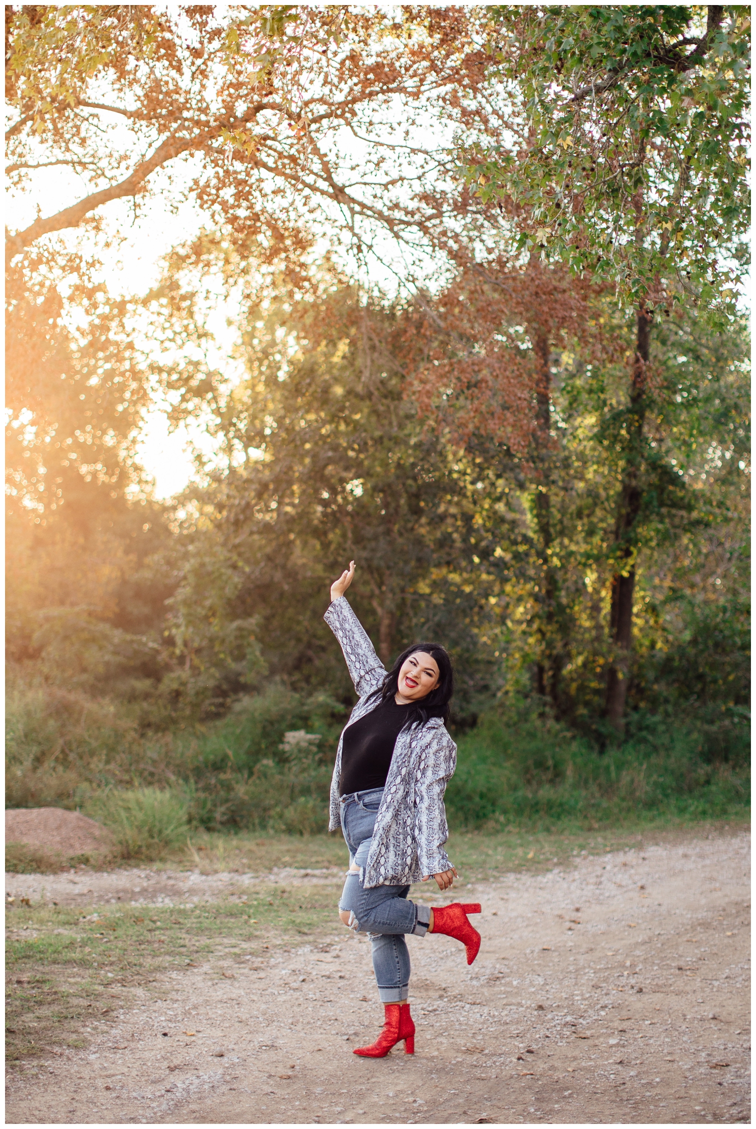 girl with hands in air and leg kicking up in sequins red boots for for senior photographer in Cypress