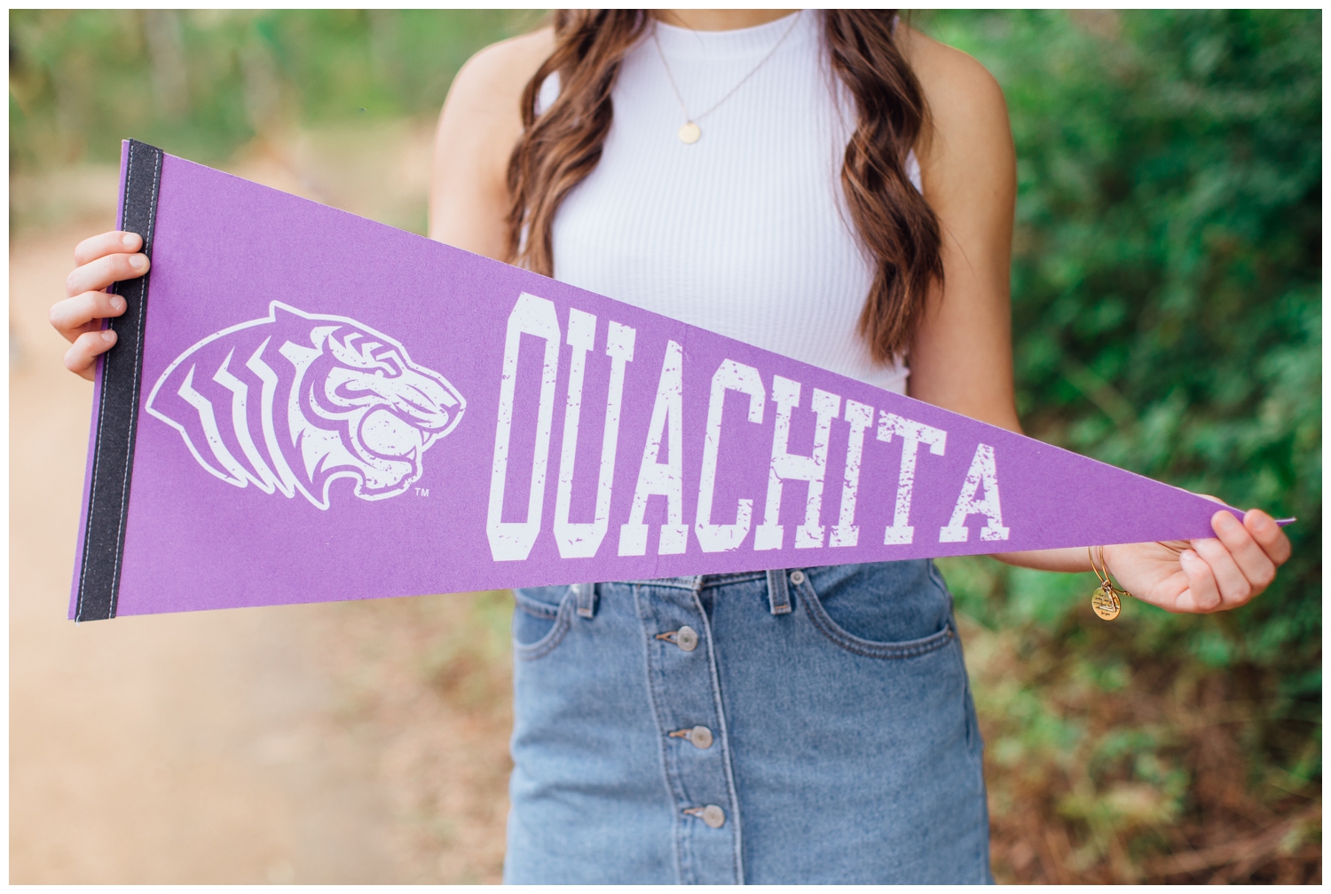 closeup image of Ouachita banner held by senior girl in white shirt