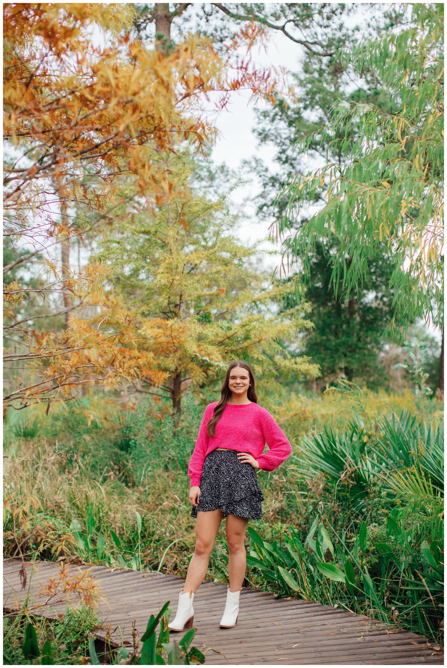 girl in pink shirt, black skirt, white boots in field at Houston Arboretum
