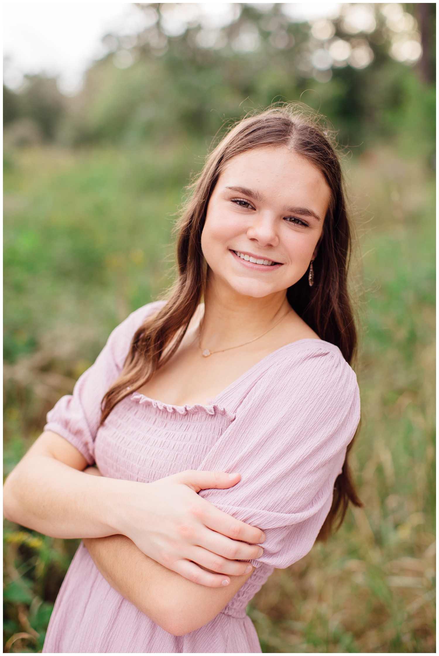 closeup portrait of girl in pink dress smiling at Senior Pictures Houston Arboretum