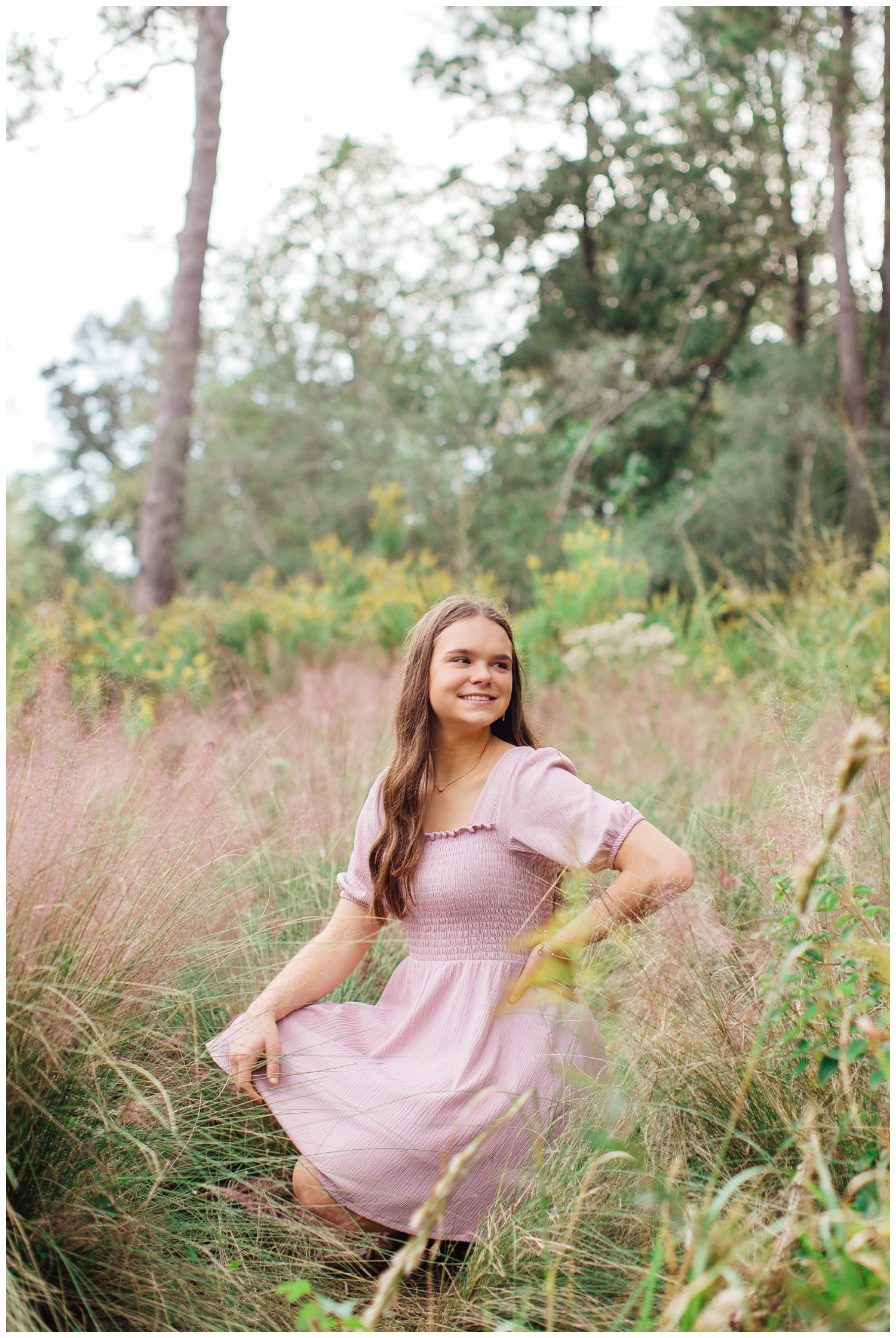 girl in pink dress kneeling in a field at Houston Arboretum