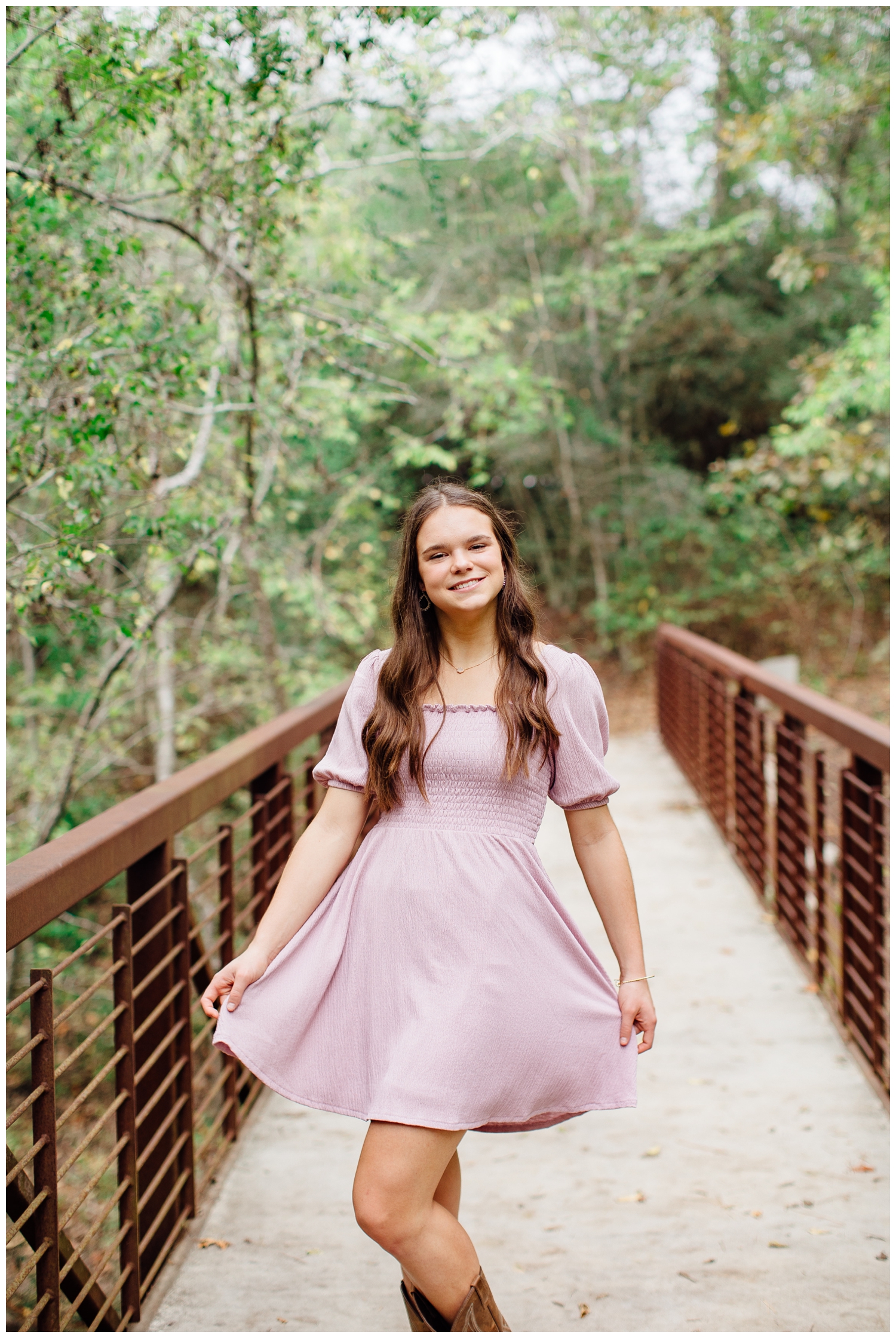high school senior girl twirling pink dress on Houston Arboretum Bridge