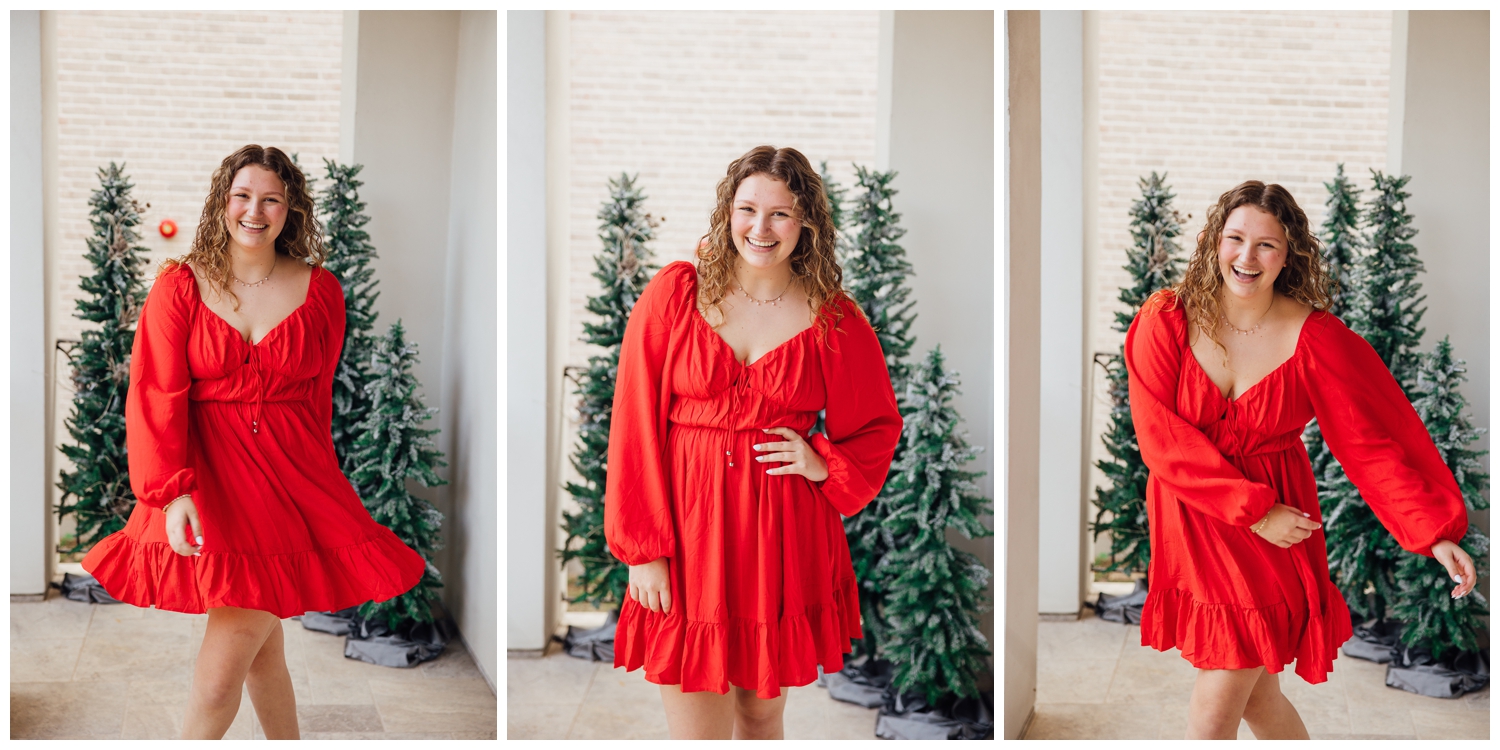 high school senior girl in red dress twirling in front of Christmas trees for Reed Gallagher Photography