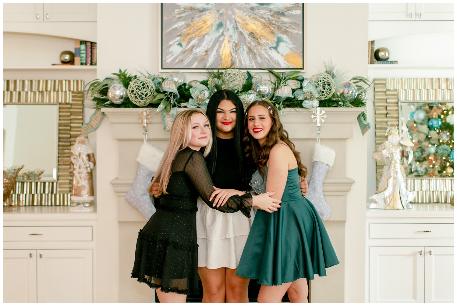 three senior girls hugging in front of gray fireplace with Christmas decor