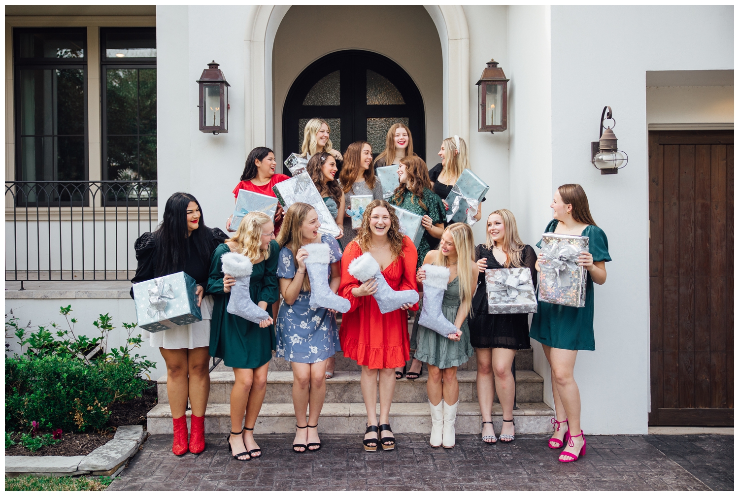 group of high school senior holding presents smiling outside a house on steps