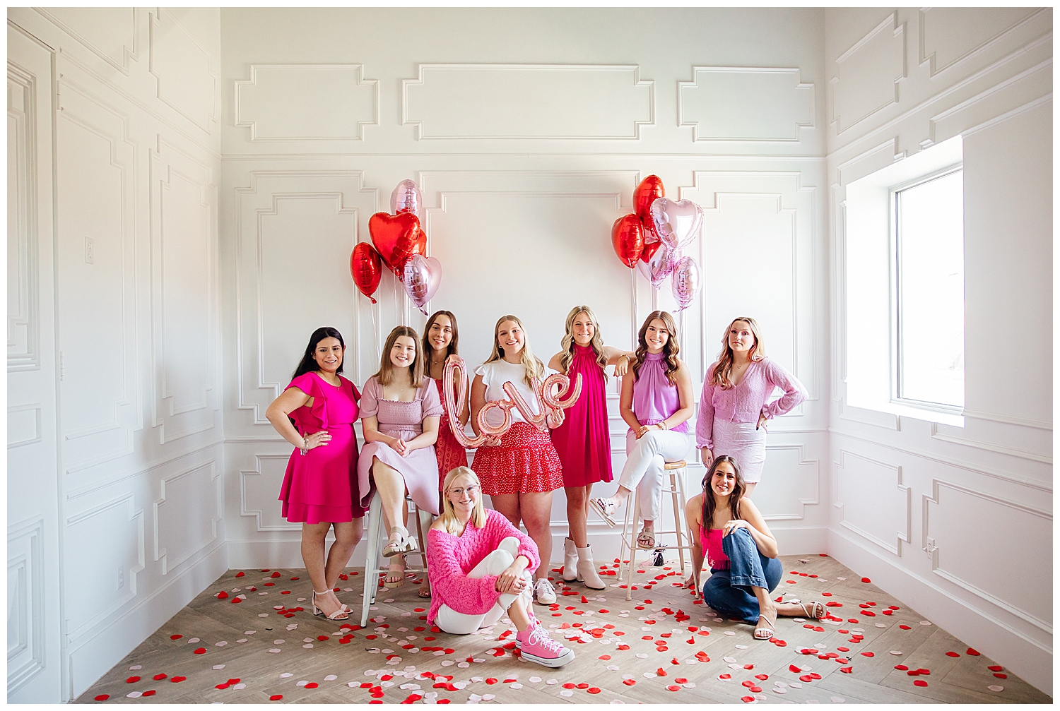 Houston senior rep team in pink red and white standing in front of white wall with heart balloons for Valentine's Day Senior Photoshoot