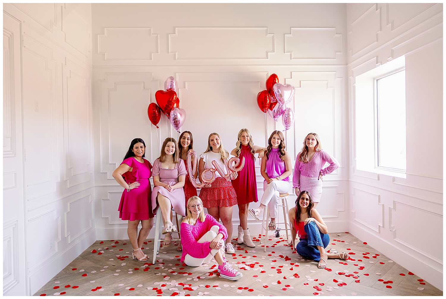 high school senior Houston rep team sitting and standing in front of white wall for Valentine's Day Senior Photoshoot