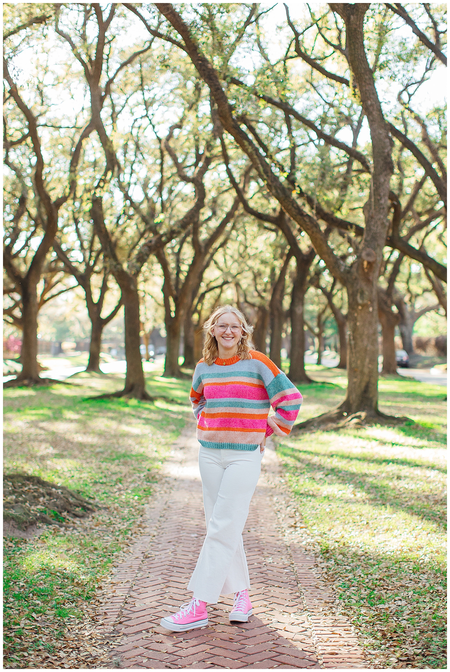 high school senior girl standing between tree line in Houston Museum District