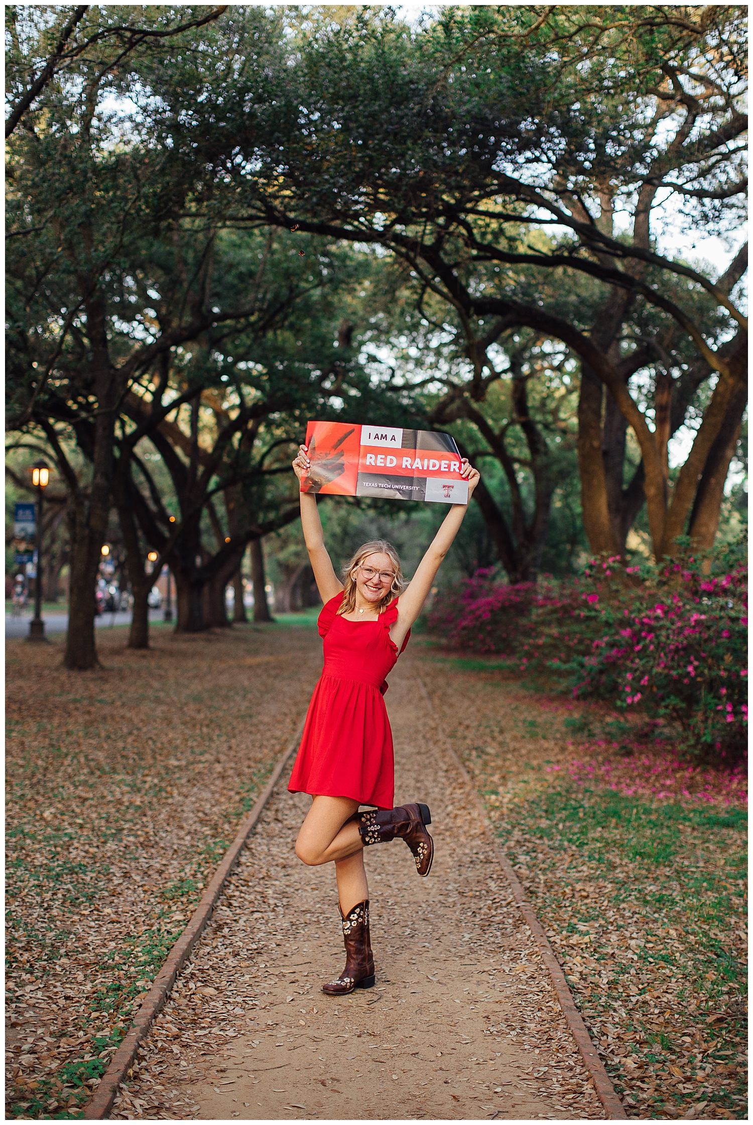 high school senior girl in red dress and boots holding texas tech sign