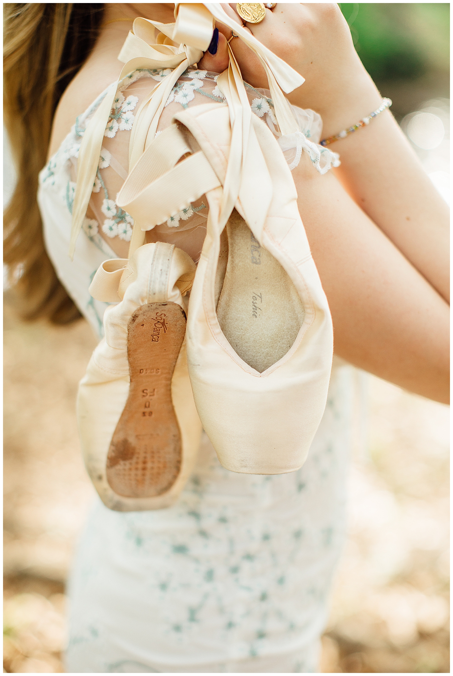 detailed image of pointe shoes being held over shoulder of high school senior girl