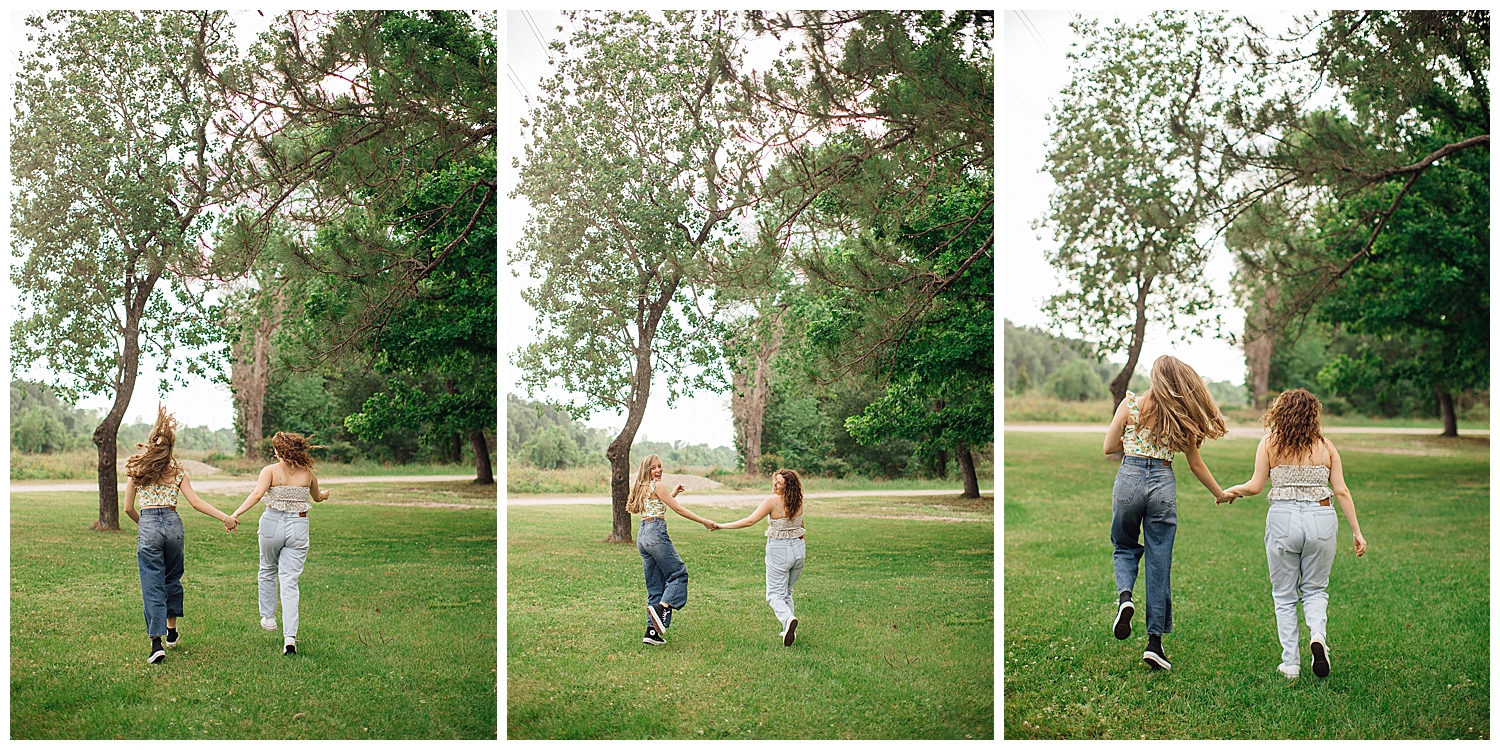 two high school senior girls holding hands and running through the grass at Cy Hope near Houston, Texas for best friends senior pictures