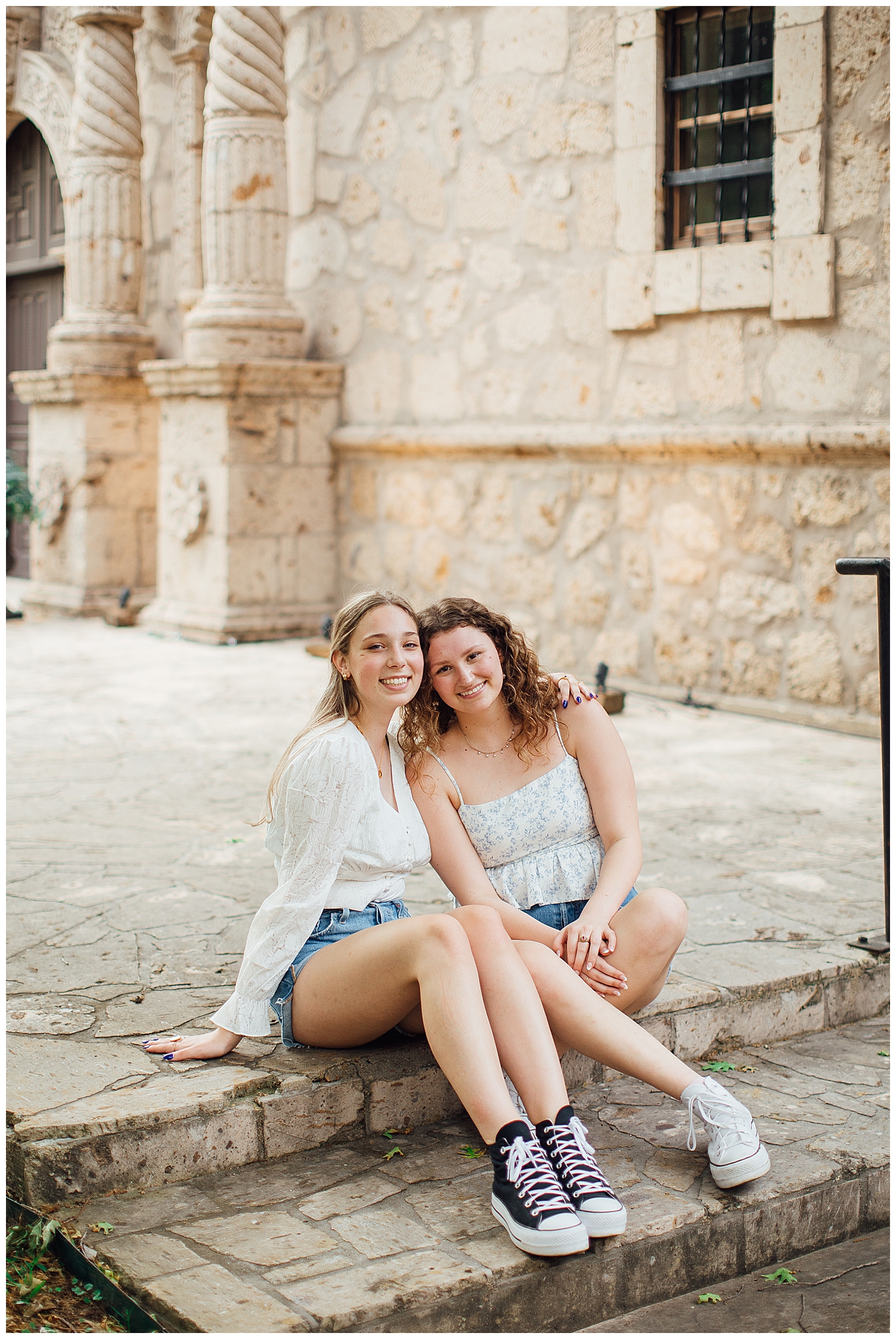 two girls sitting on a step outside at Cy Hope for best friends senior pictures