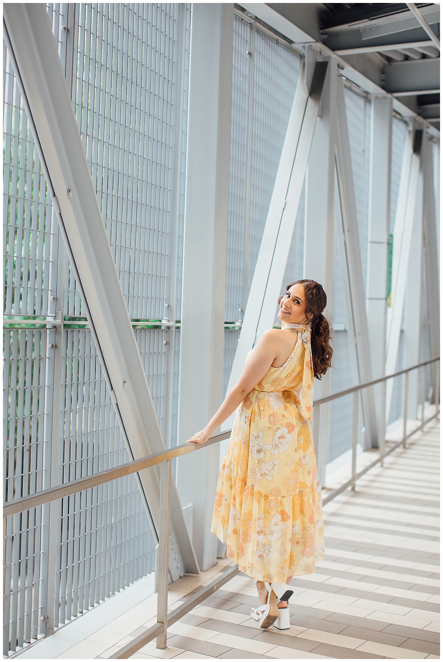 girl in floral, yellow dress in Houston downtown on skybridge