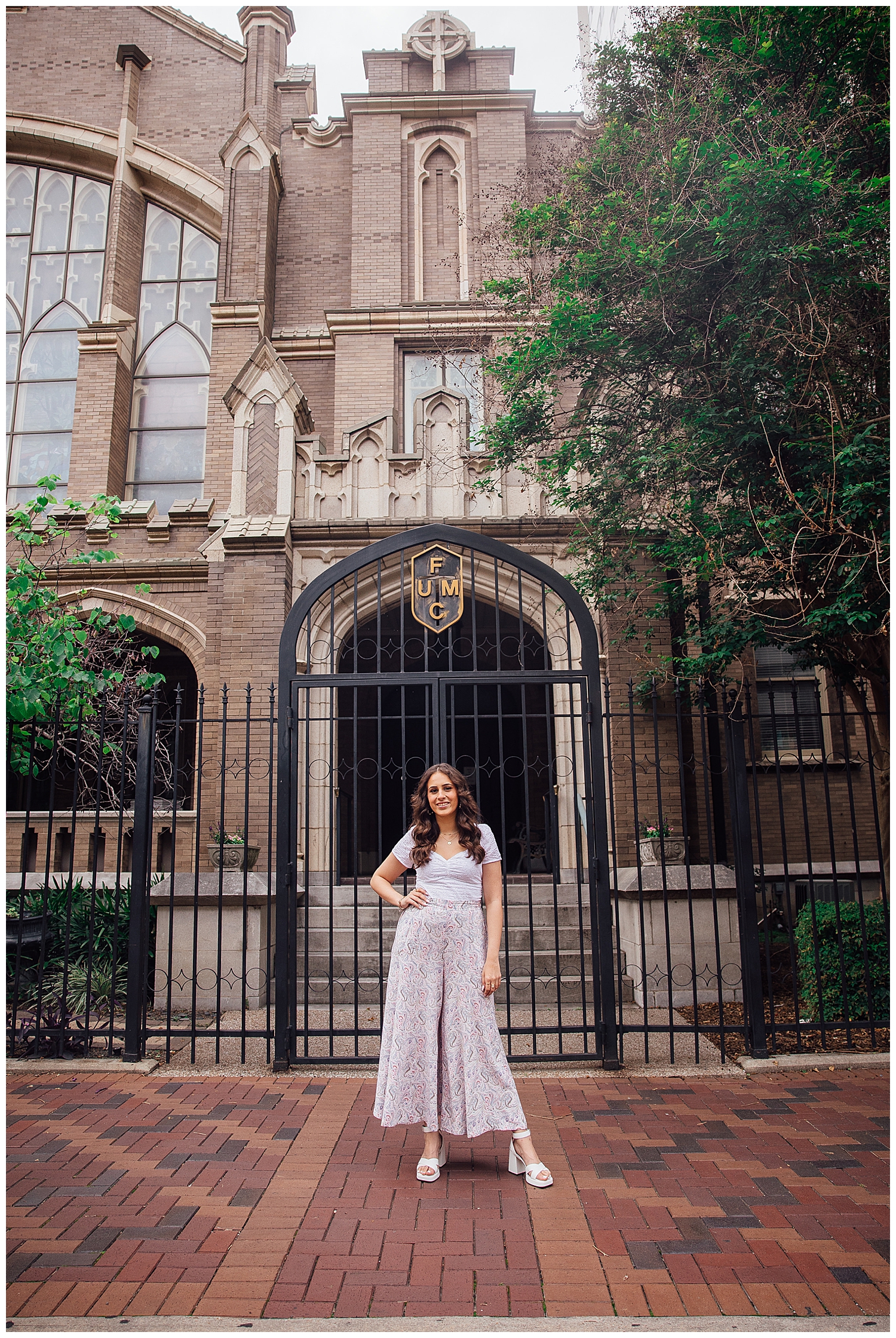 high school senior girl standing in front of church downtown Houston senior pictures in white pants and white shirt
