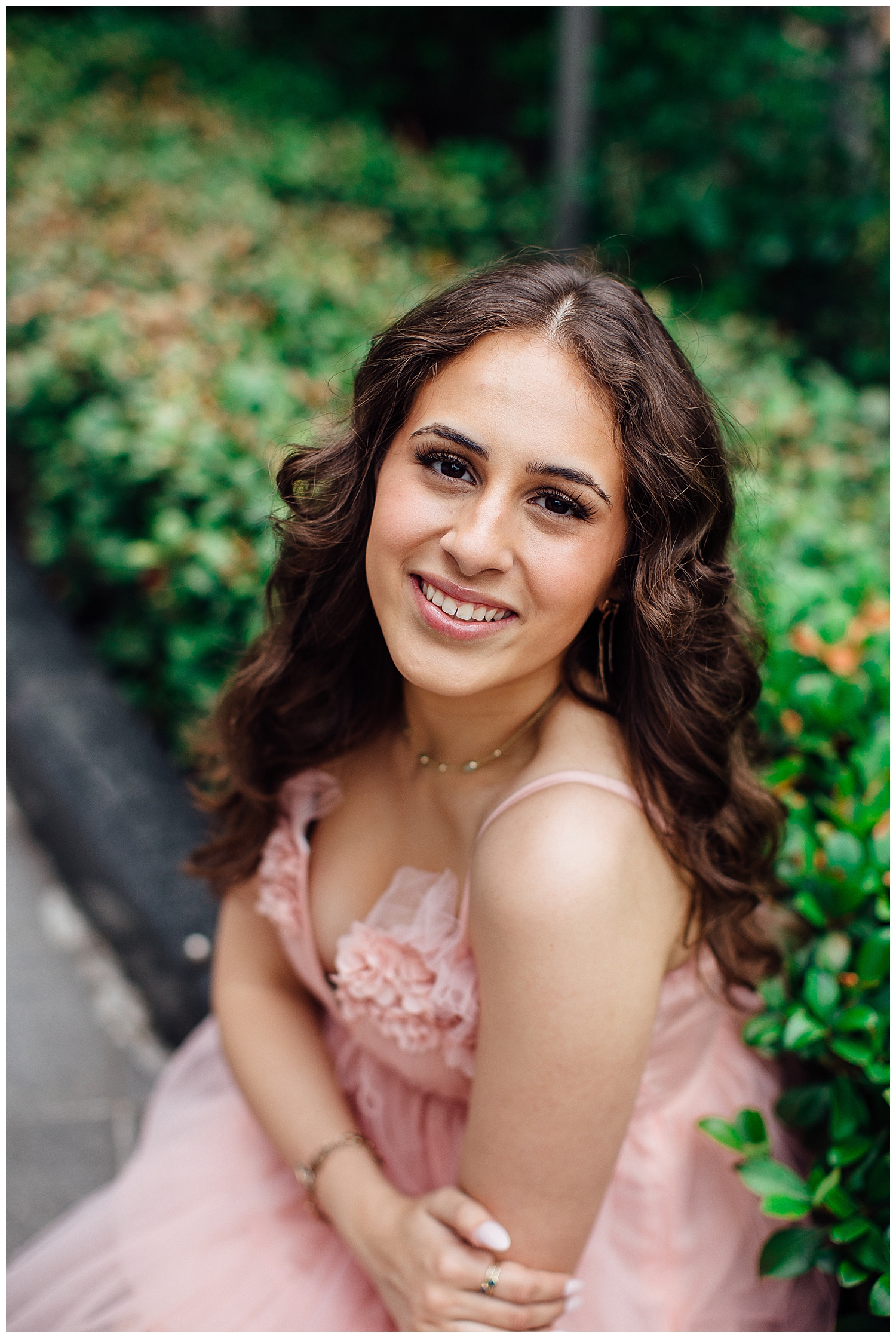 closeup image of girl smiling sitting in front of flowers in downtown Houston senior pictures