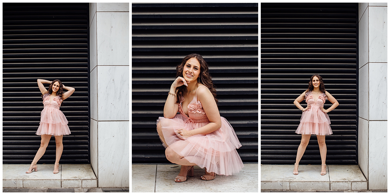 girl in pink fluffy dress standing in front of dark wall for downtown Houston senior pictures
