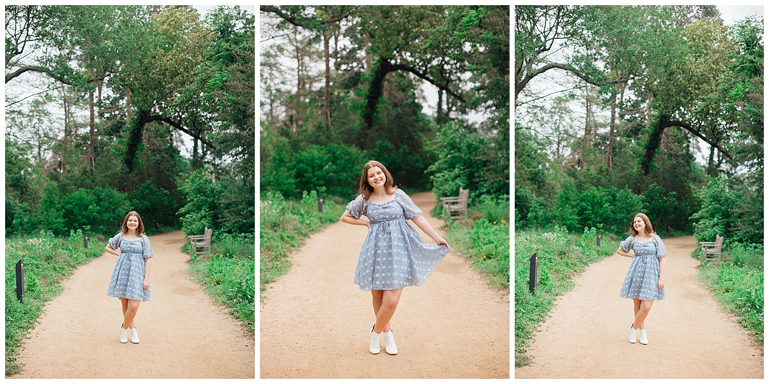 high school senior girl in blue dress standing on a pathway inside Houston Arboretum for outdoor spring senior photos