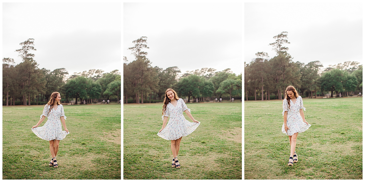 high school senior girl in white dress with flowers dancing in a field at Hermann Park for outdoor senior photos Houston