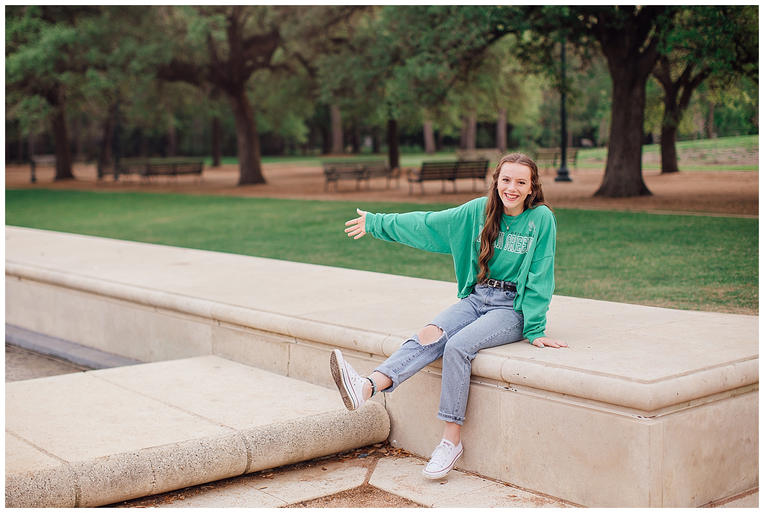 Houston senior girl in jeans and long sleeved green tshirt sitting on column at Hermann Park
