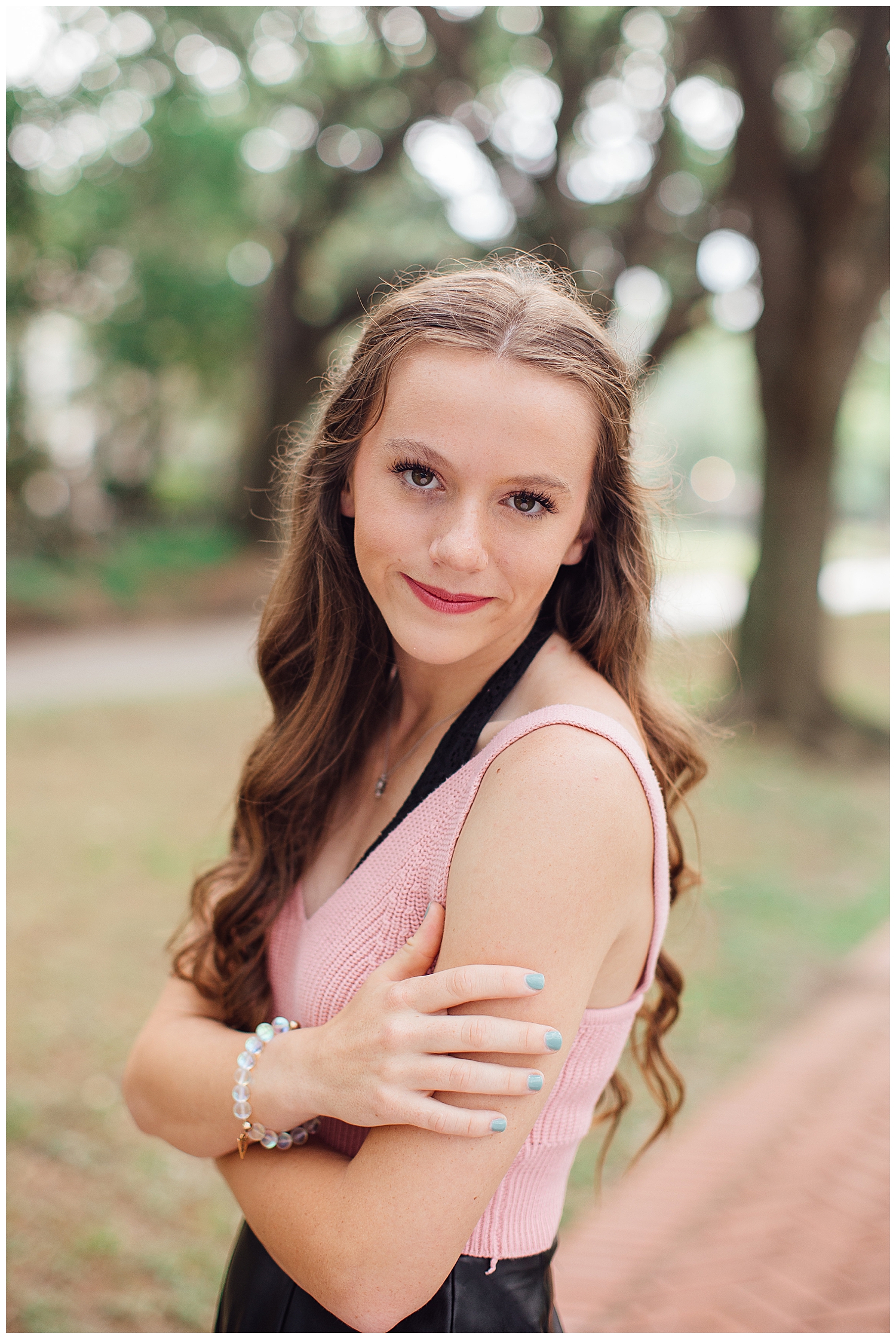 close up image of girl in blush sweater with arms crossed outdoor senior photos Houston at North South Blvd