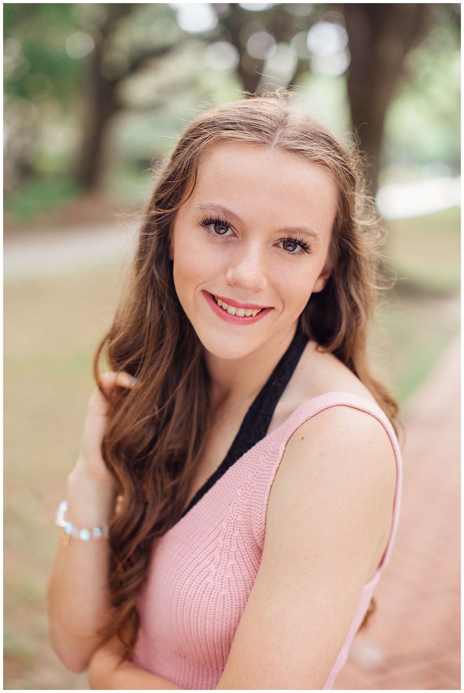 high school senior girl smiling at camera in blush sweater for Reed Gallagher Photography
