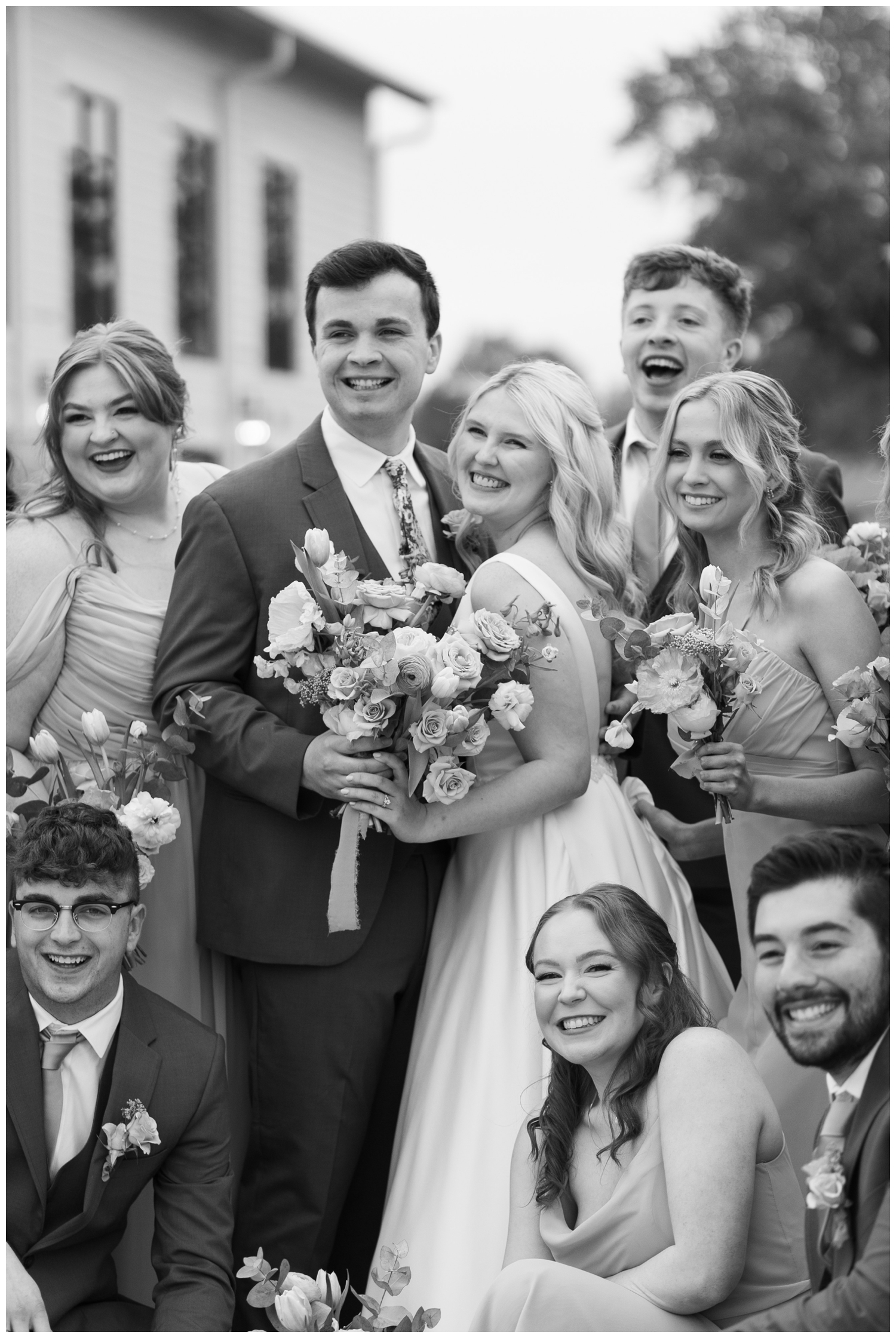 black and white image of bridal party outdoors smiling