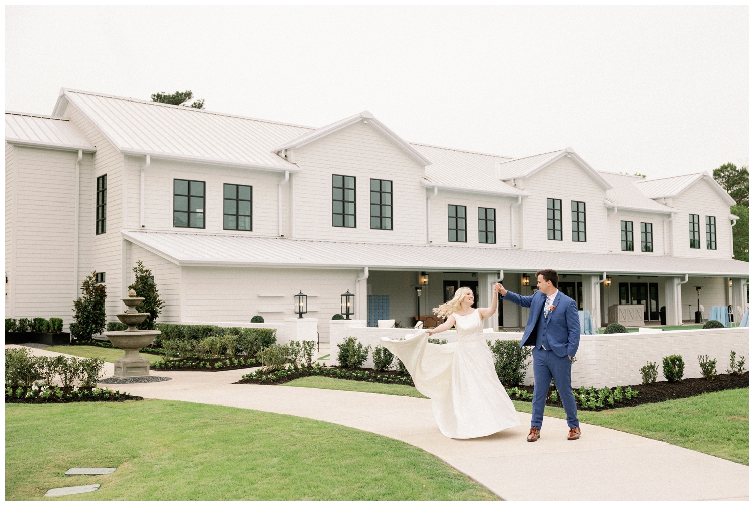 groom twirling his bride in front of Boxwood Manor Wedding venue in Tomball Texas