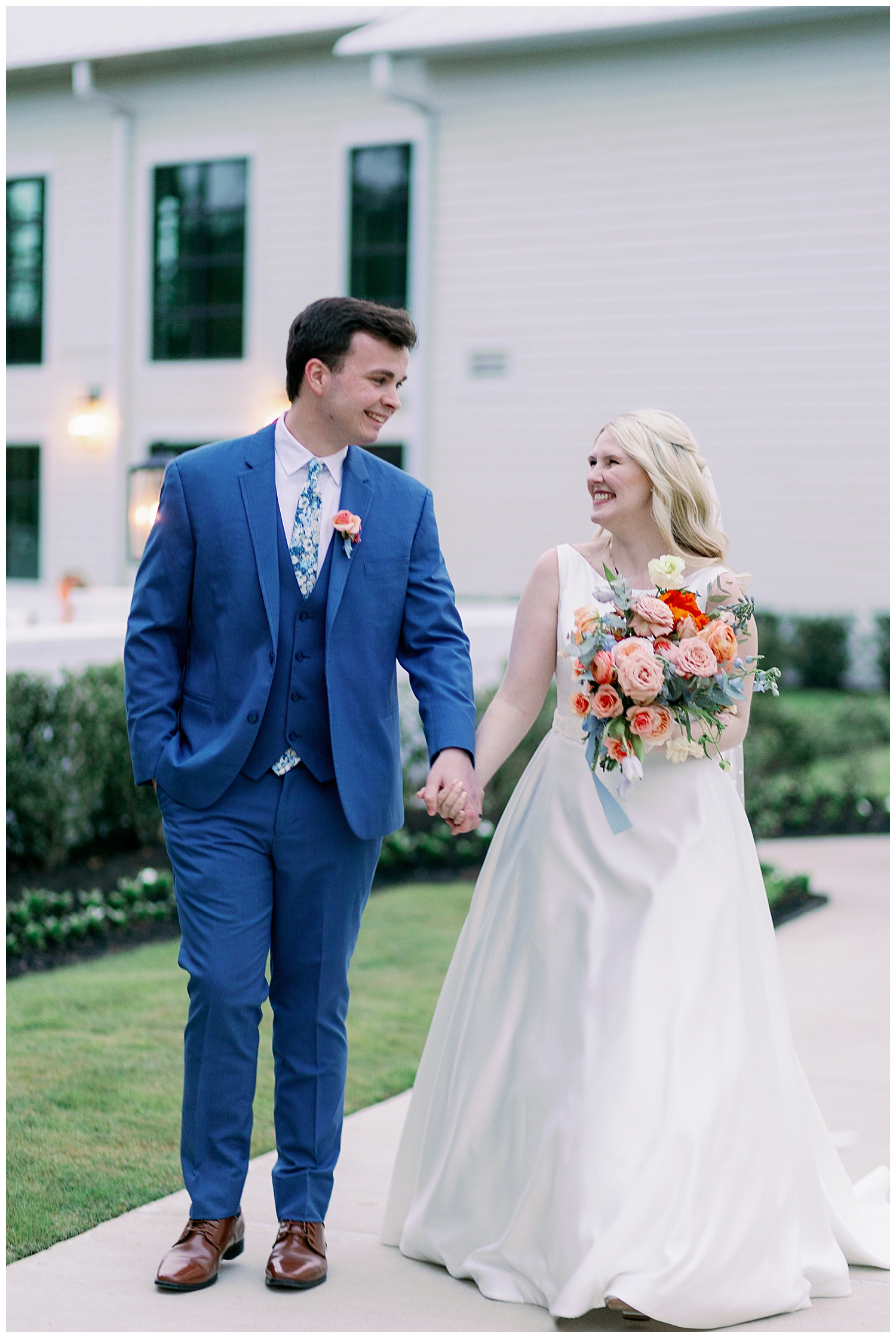 bride and groom holding hands and laughing walking outside Boxwood Manor wedding
