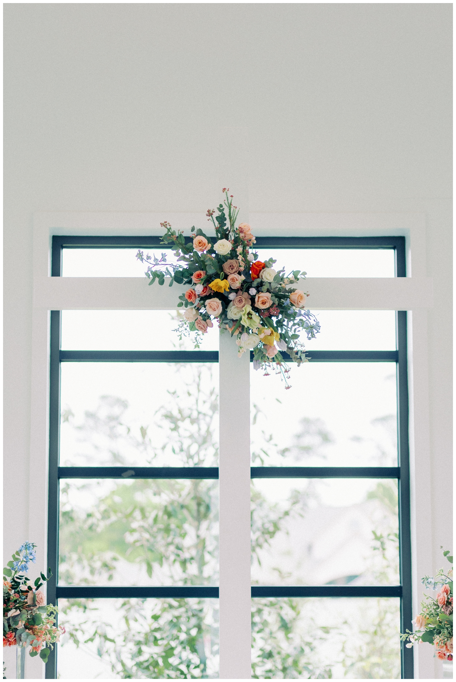 cross adorned with florals inside Boxwood Manor Wedding chapel