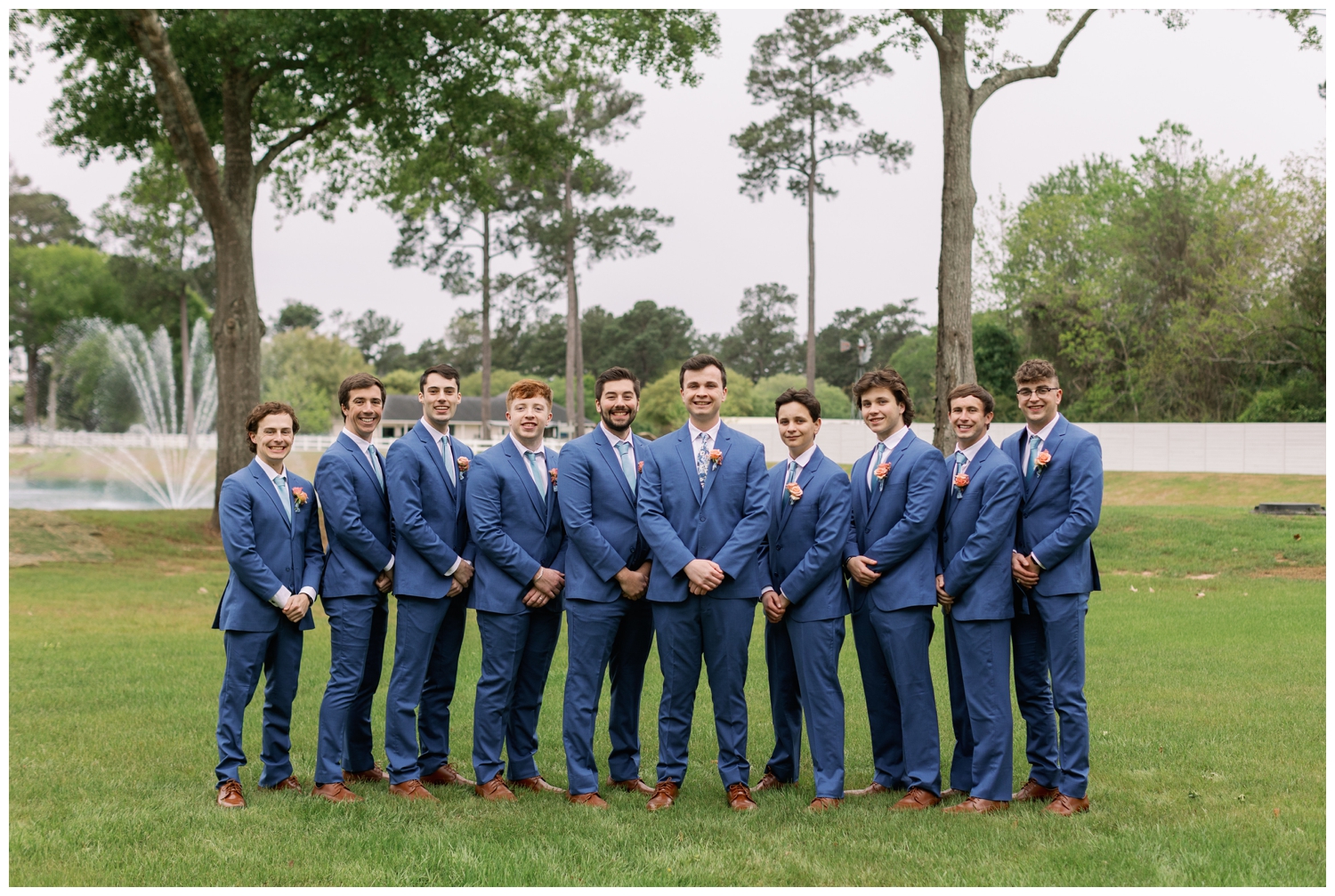 groom and groomsmen in blue suits standing in straight line