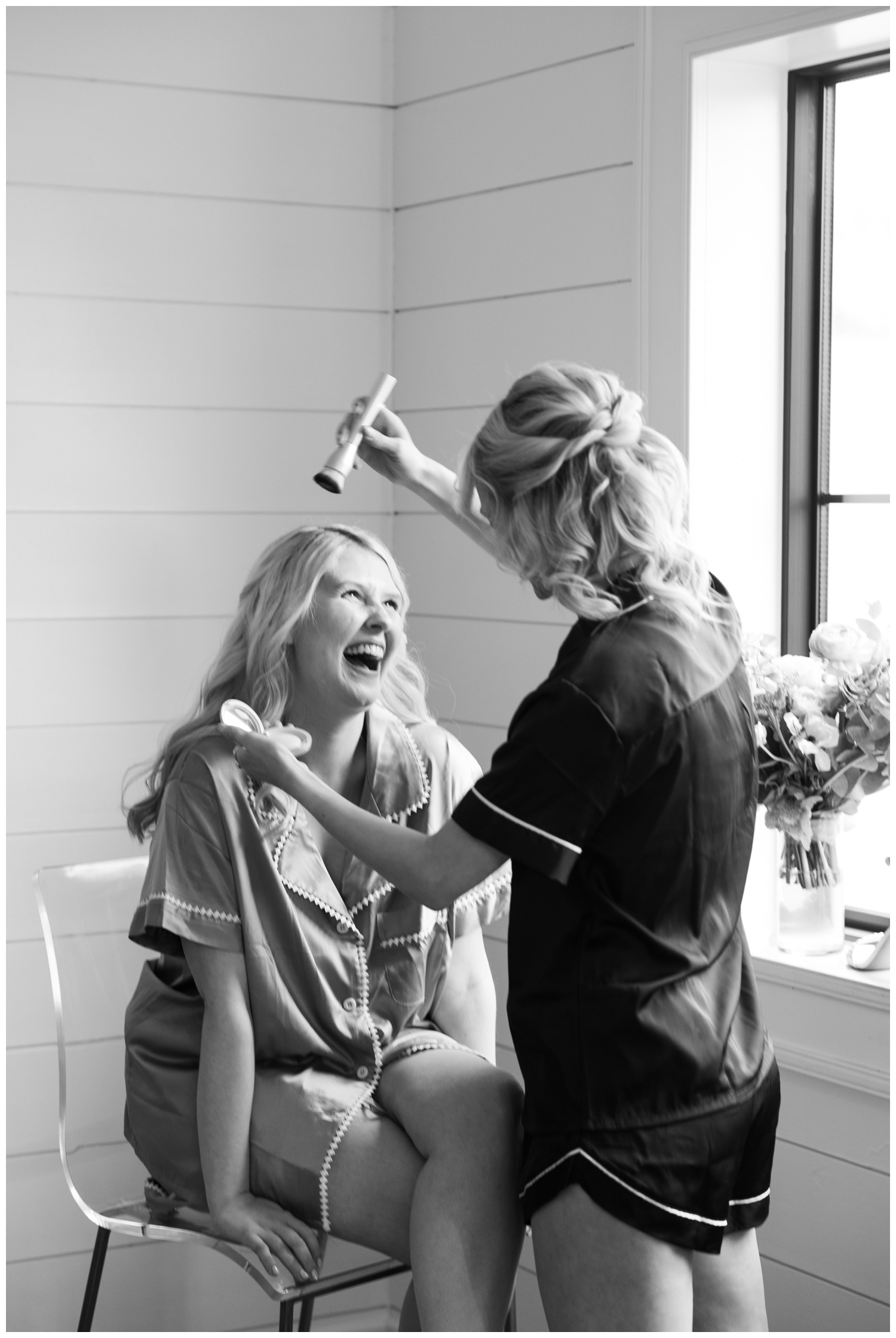 black and white image of bride laughing during hair and makeup