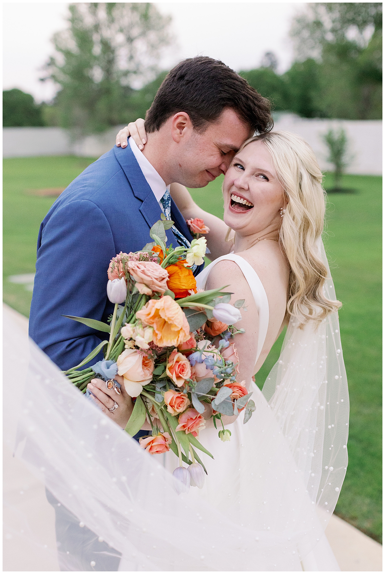 bride and groom portrait outside Boxwood Manor with veil swoop and bride laughing