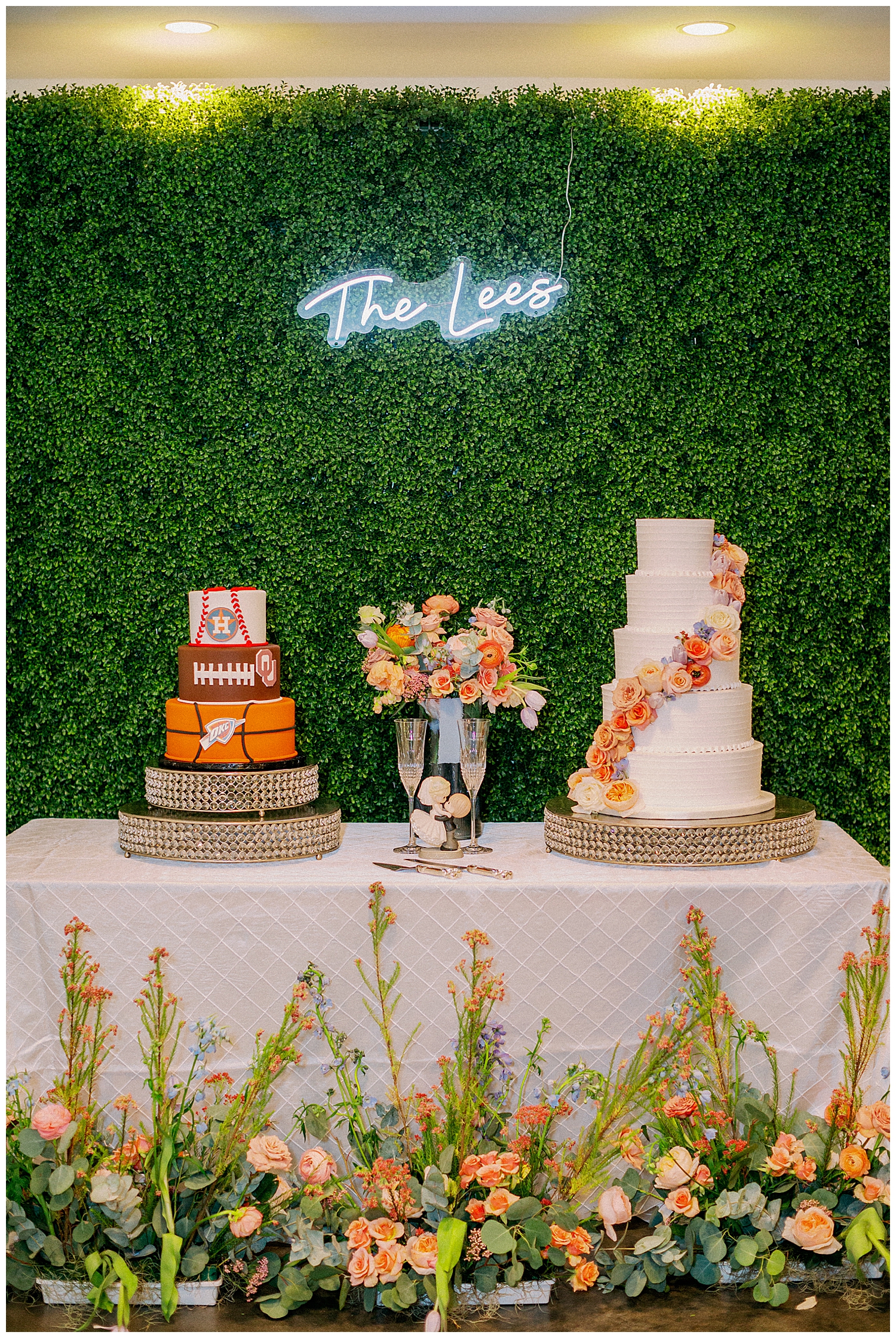 bride and groom cake table with greenery wall