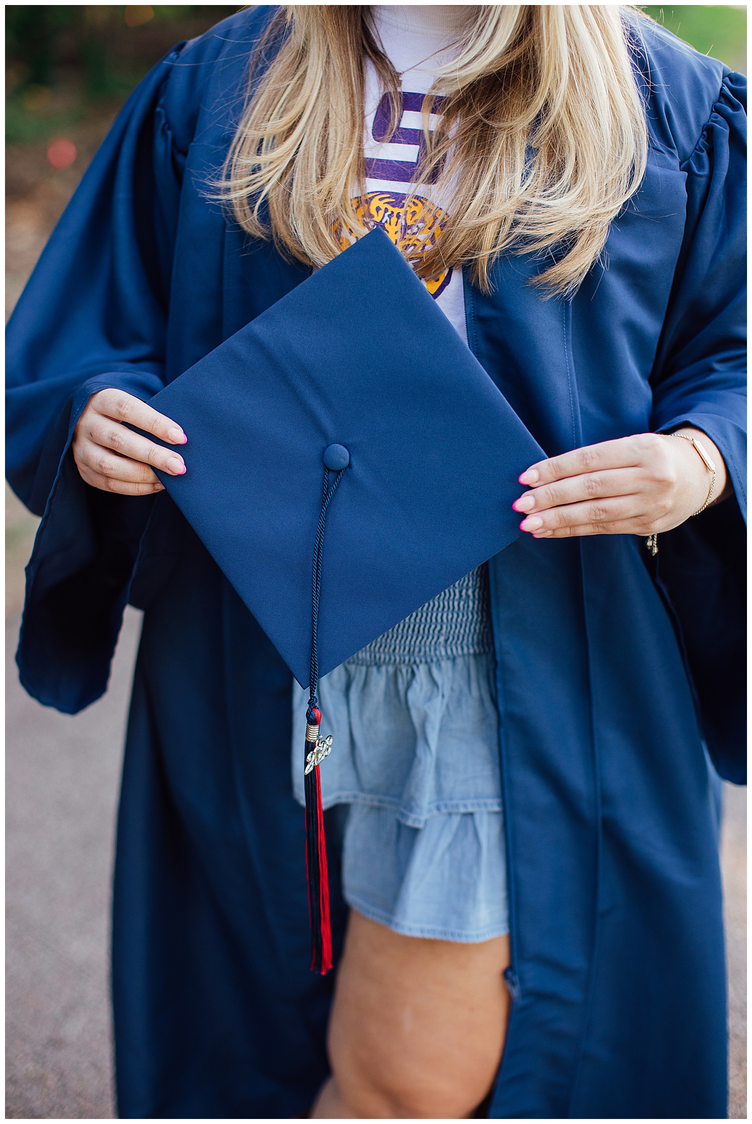 close up of senior girl holding navy cap with tassel