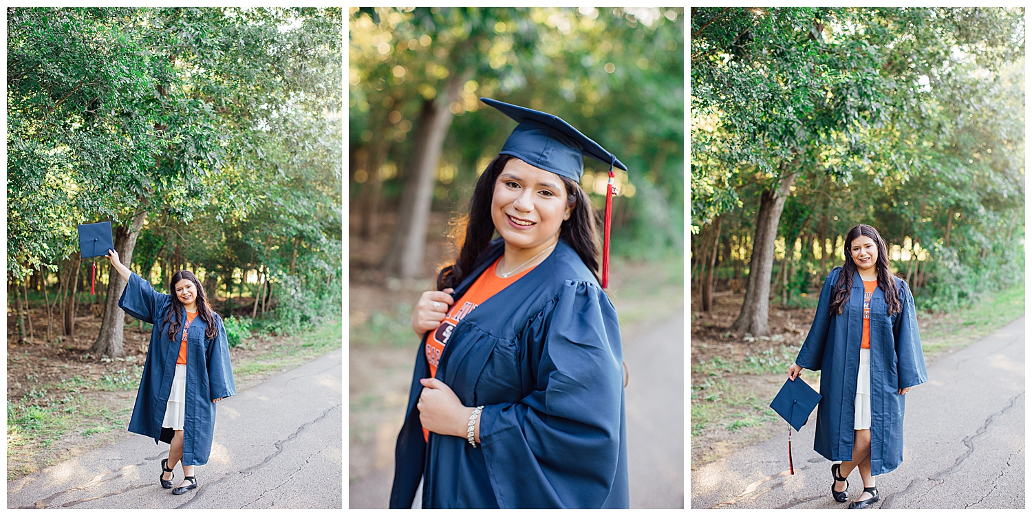 senior girl posing holding cap and wearing navy grad gown on pathway in houston, texas