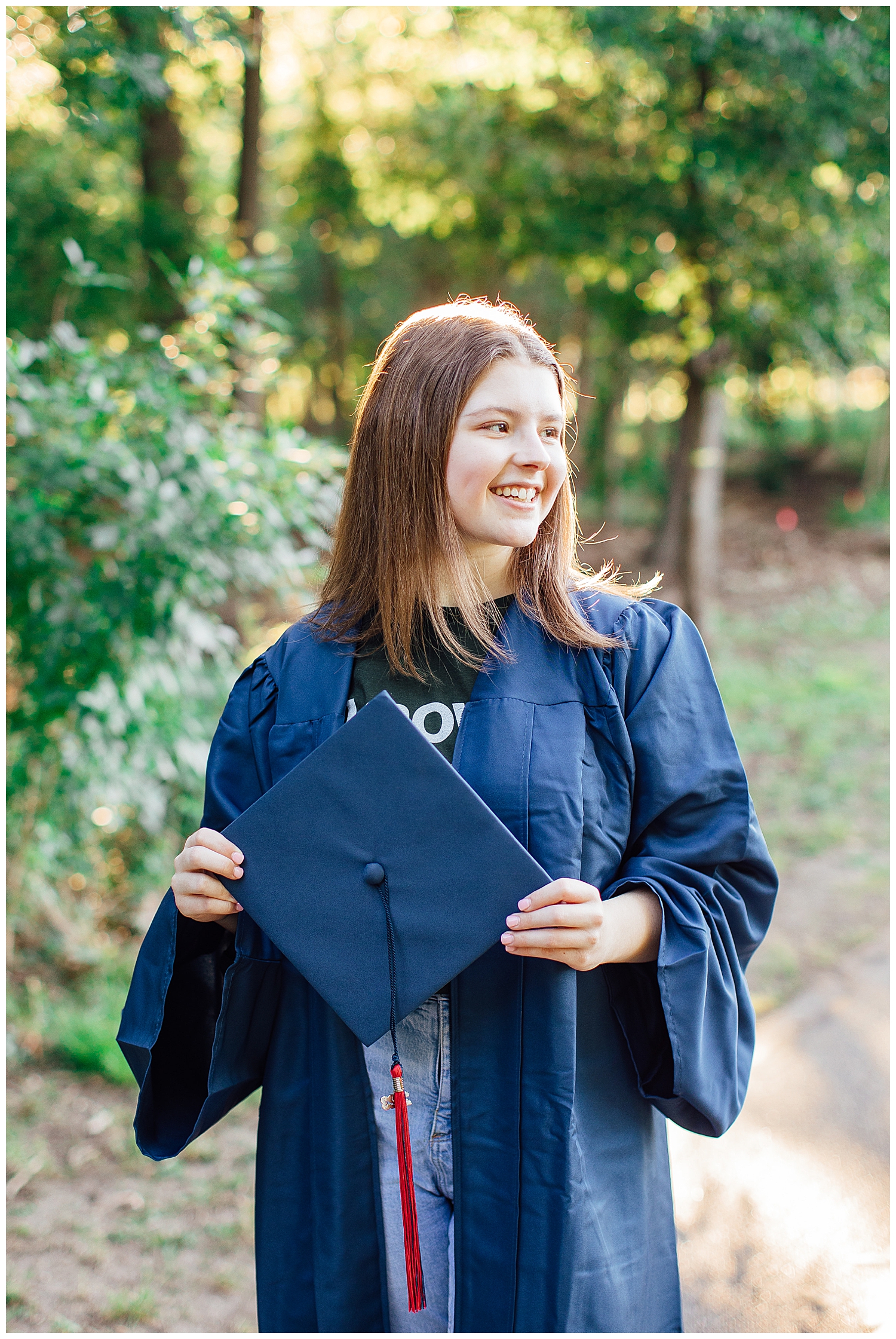 senior girl holding navy cap in park in houston, texas for cap and gown senior pictures