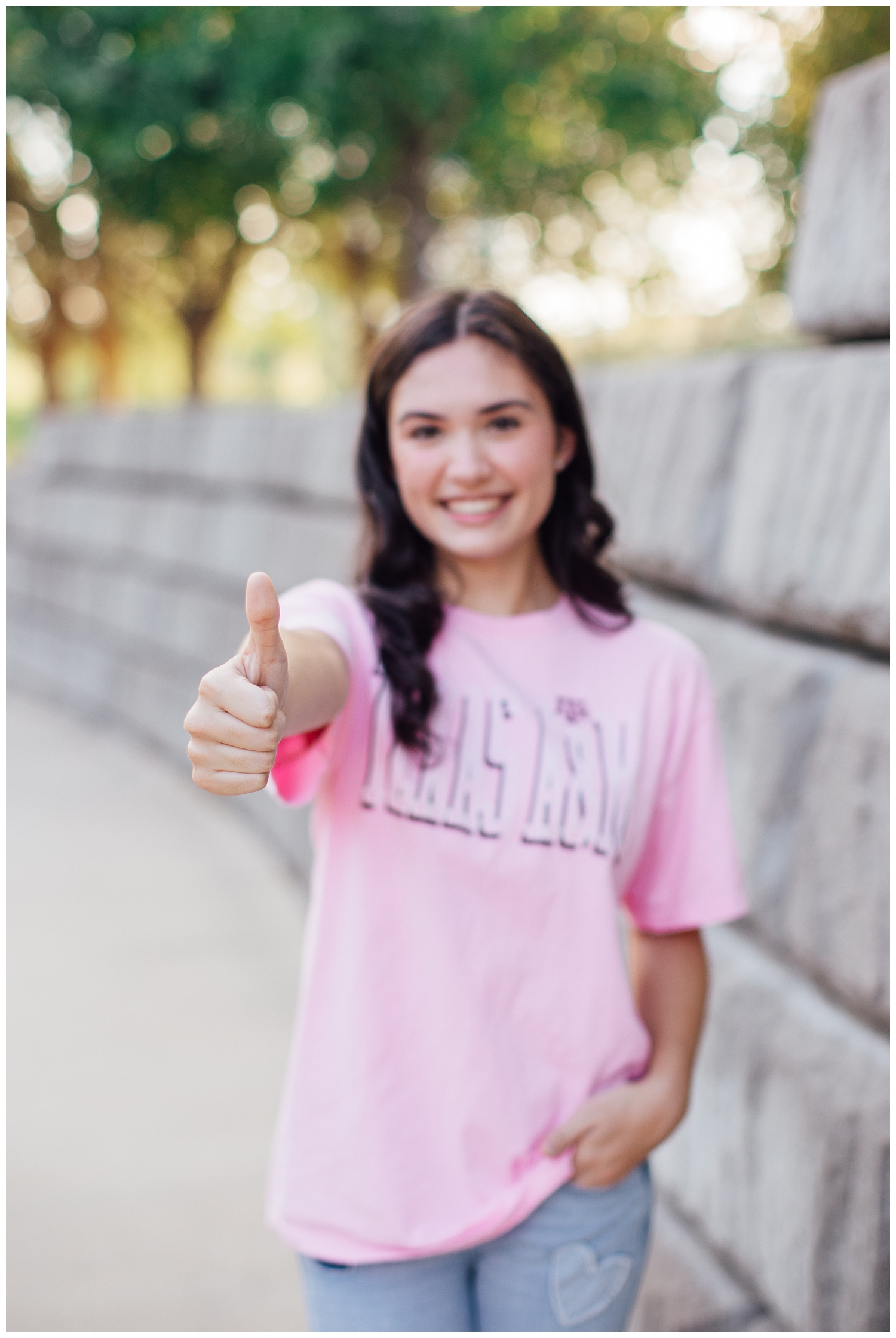 senior girl in pink texas aggie tshirt with thumb sign