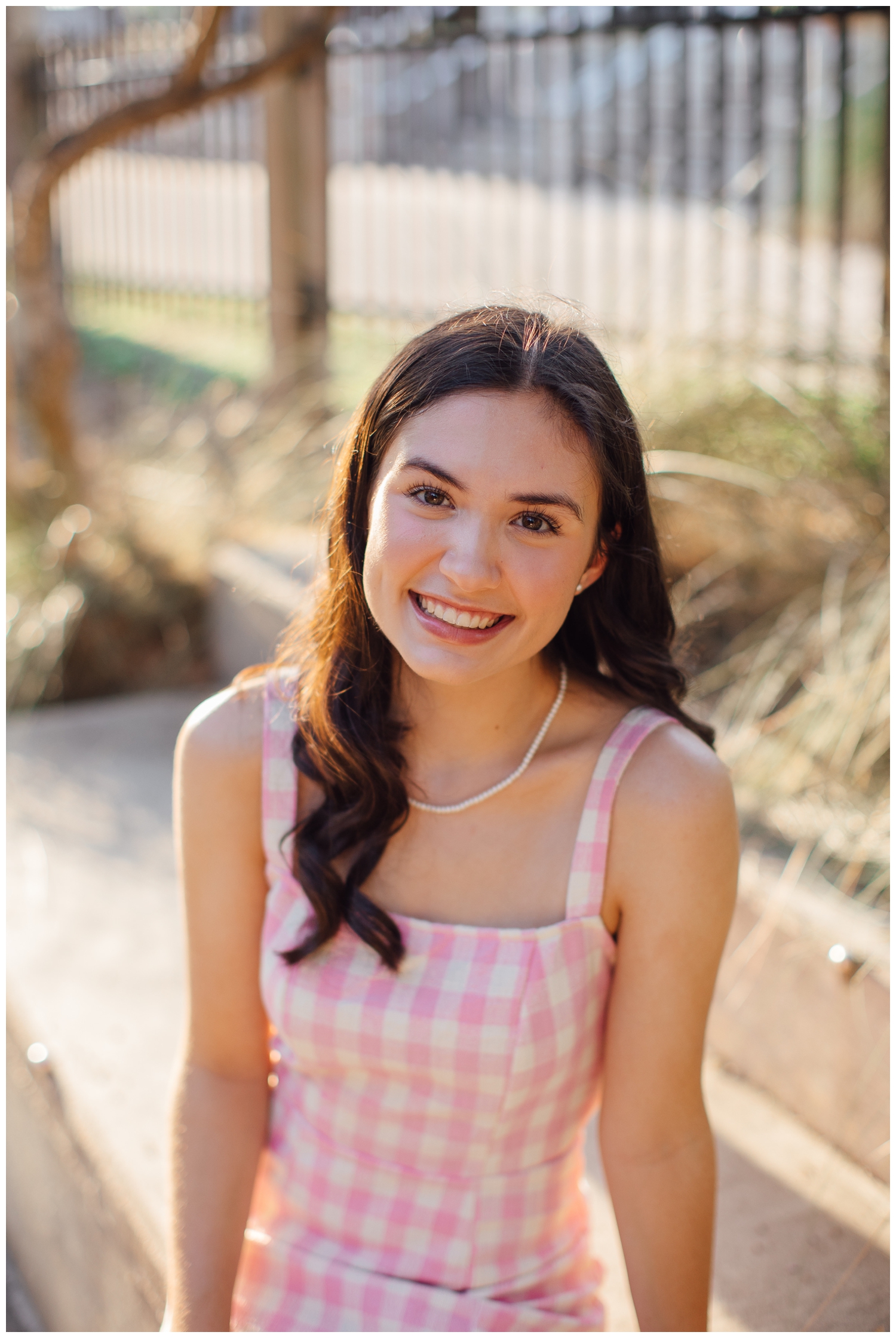 close up image of girl in pink dress smiling for senior photos Houston Texas