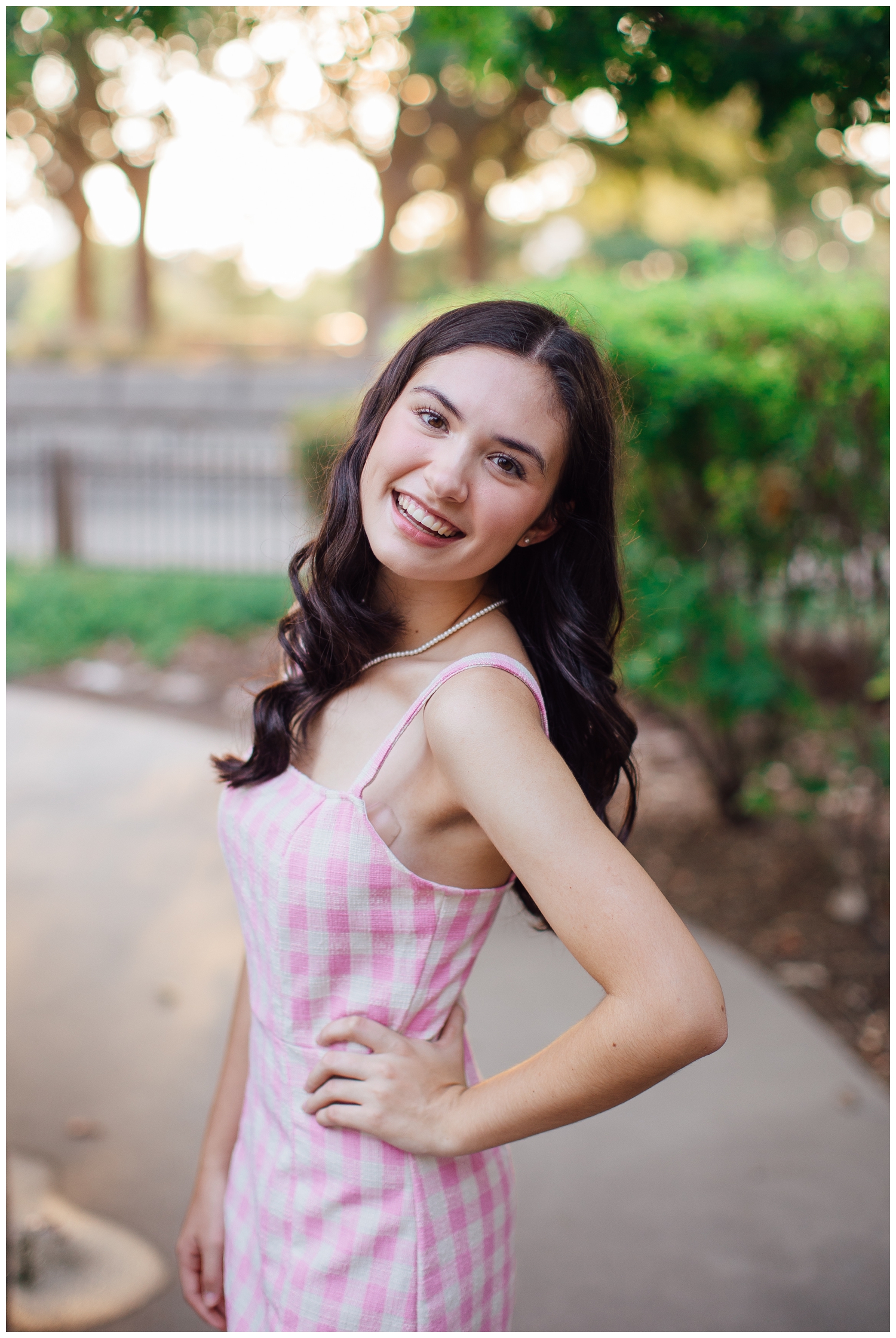 close up image of senior girl smiling with hand on hip outdoors for senior photos Houston at Sabine Street