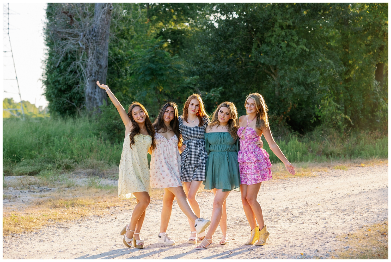 five high school senior girls in sundresses posing for senior rep team Houston pictures outdoors