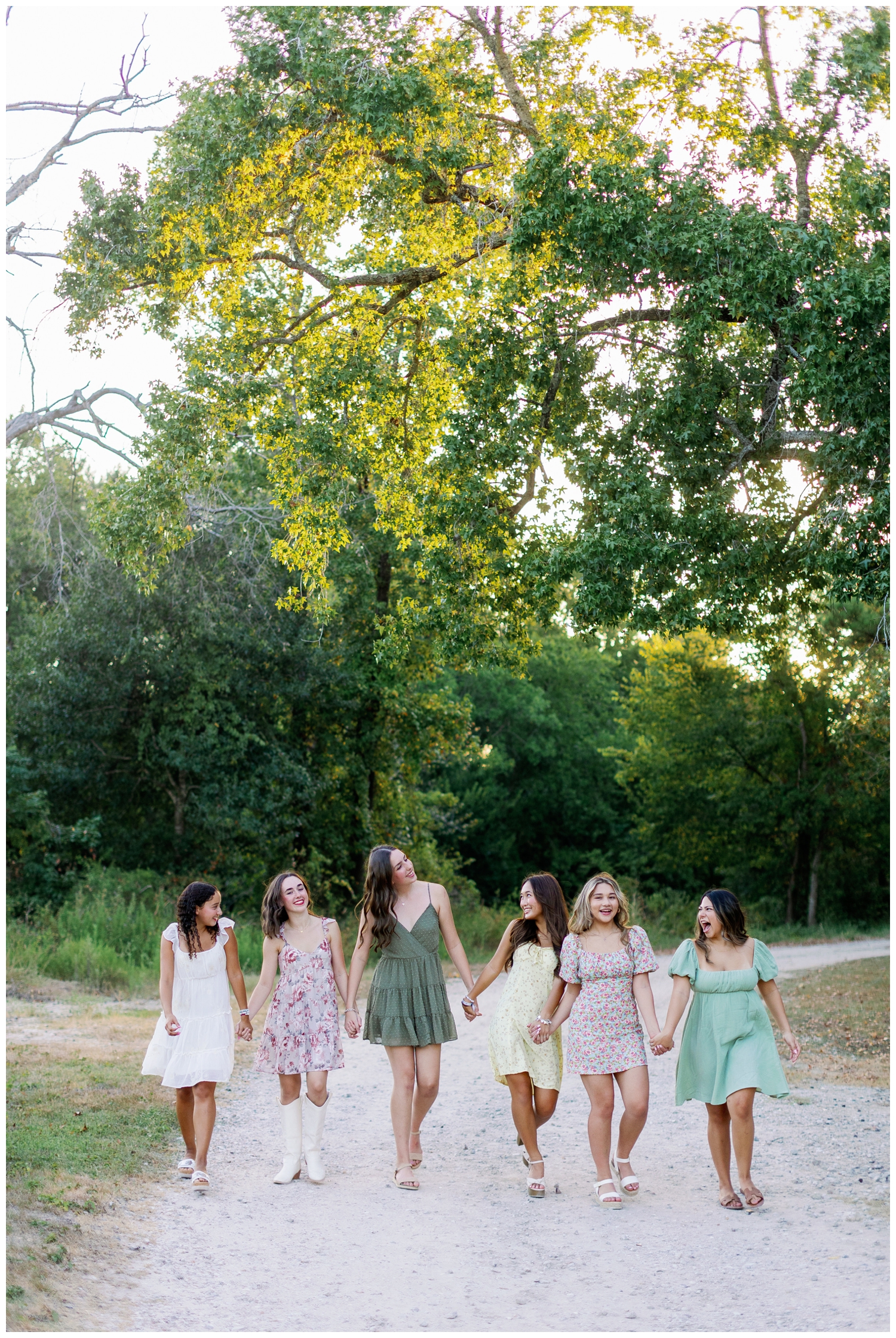 senior rep team Houston girls in sundresses walking and holding hands outdoors cy hope