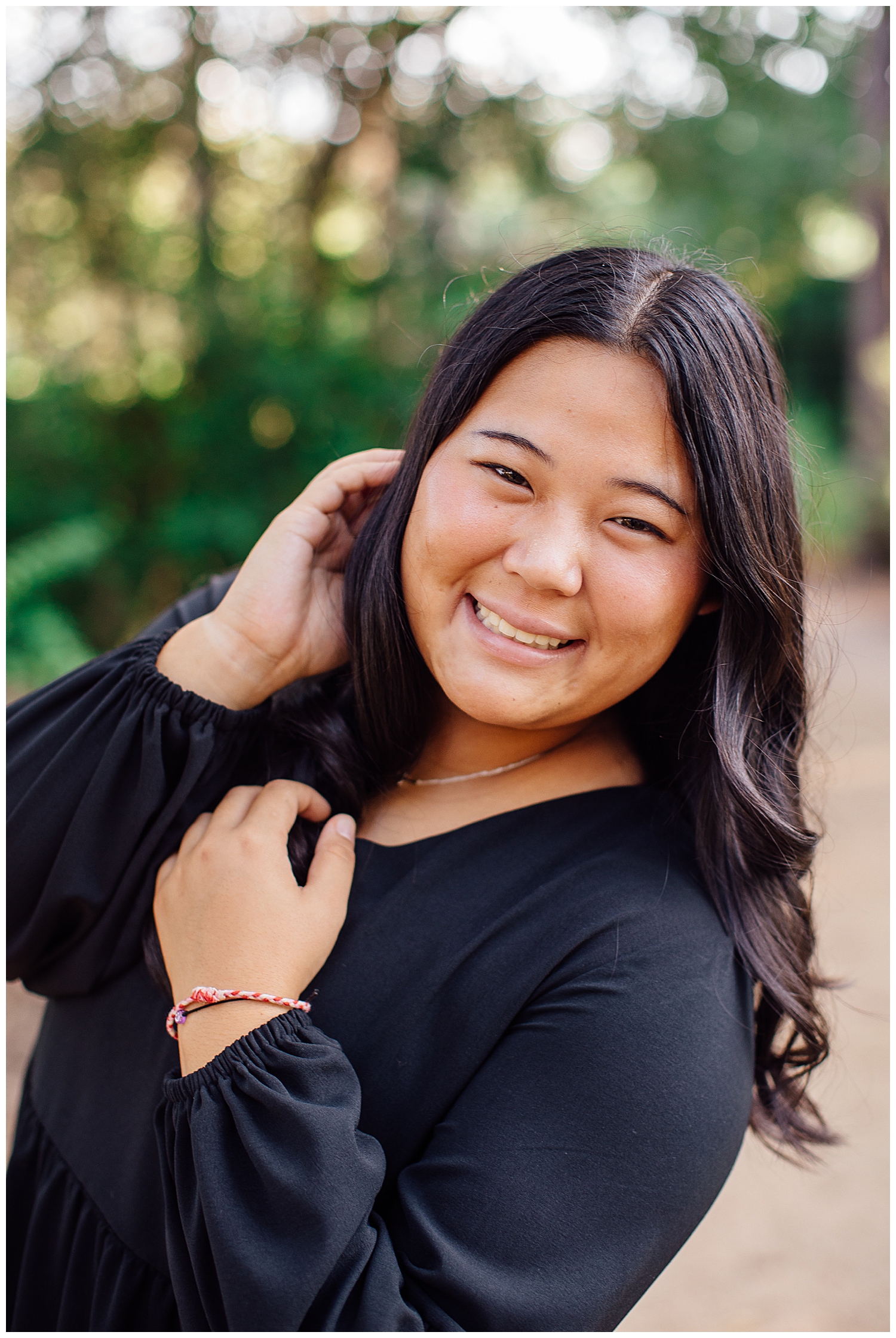 high school senior girl in black dress with hands in hair closeup at Houston Arboretum