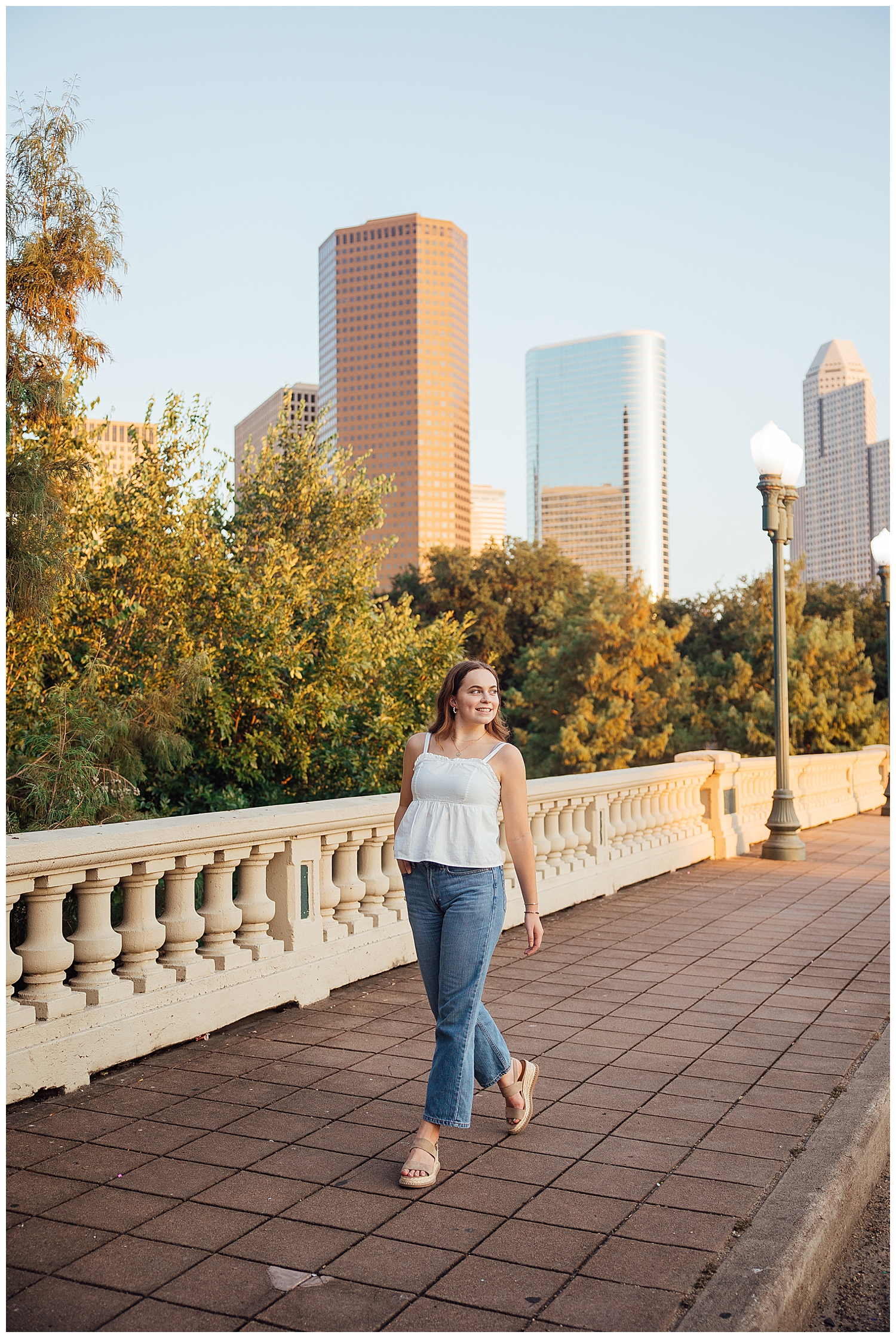 girl walking on Sabine Street bridge with Houston skyline