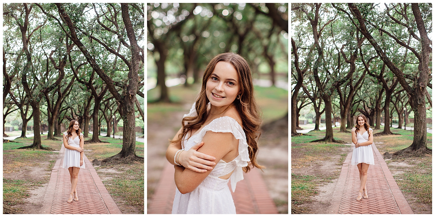 high school senior girl in white dress standing between trees Houston outdoor senior photos