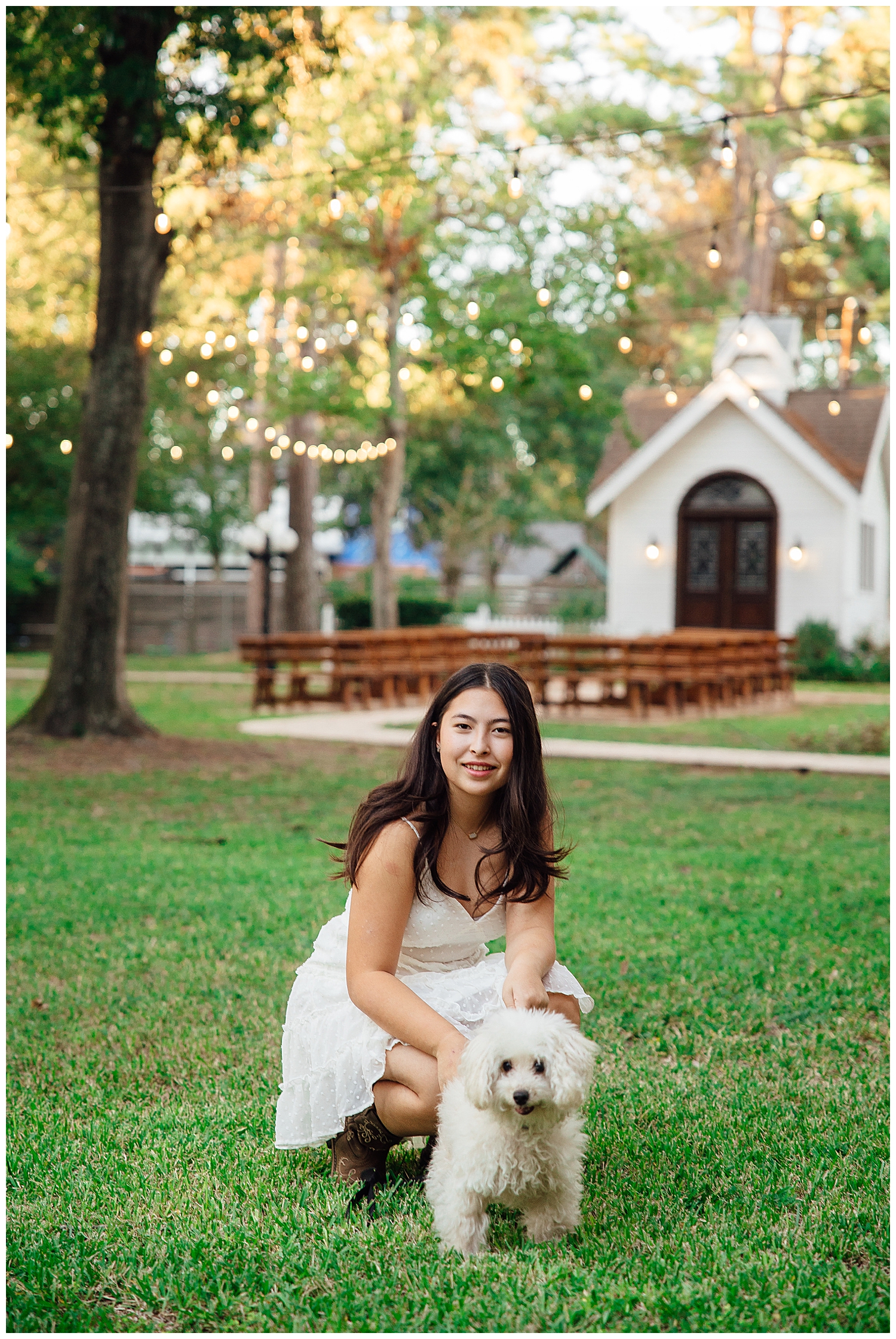 high school senior girl squatting with her dog in a white sundress for Cypress outdoor senior photographer