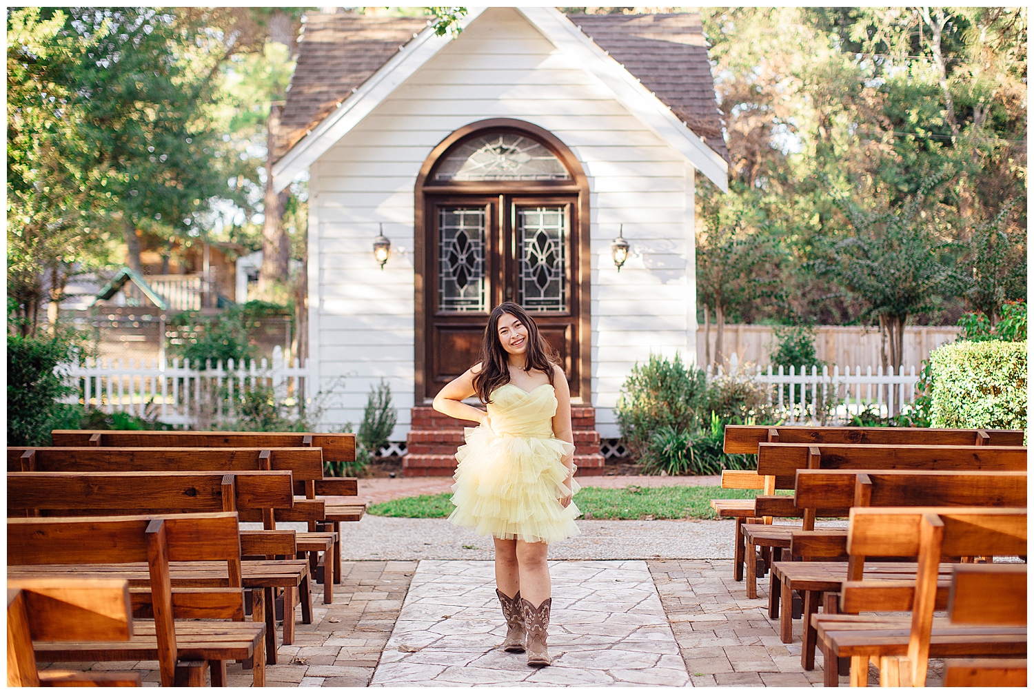 high school senior girl in yellow fluffy dress and boots standing in front of white church