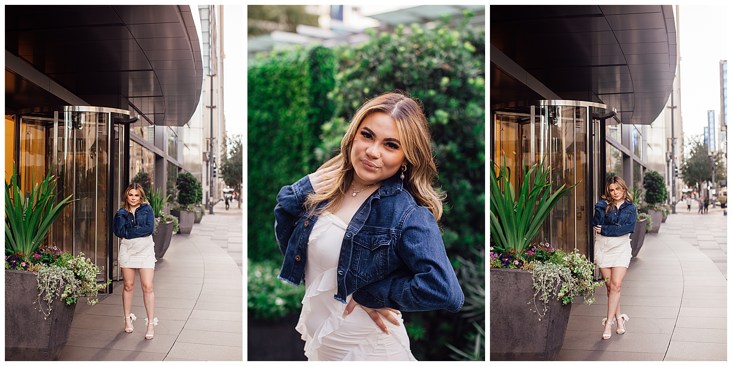 Houston downtown senior photos where high school girl in white dress with denim jacket in front of greenery