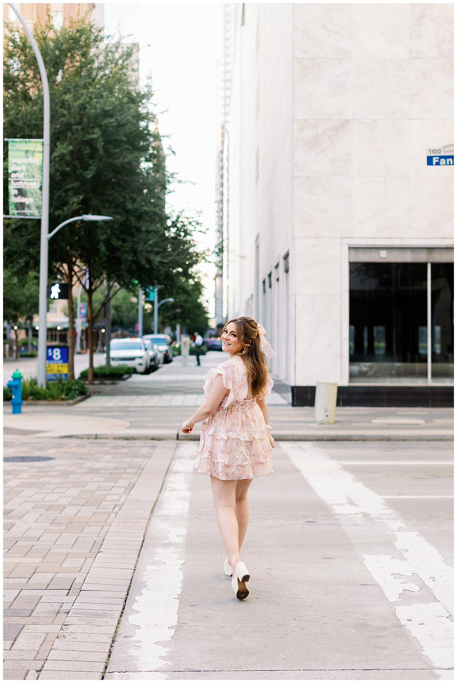 high school girl crossing main street houston downtown in floral sundress