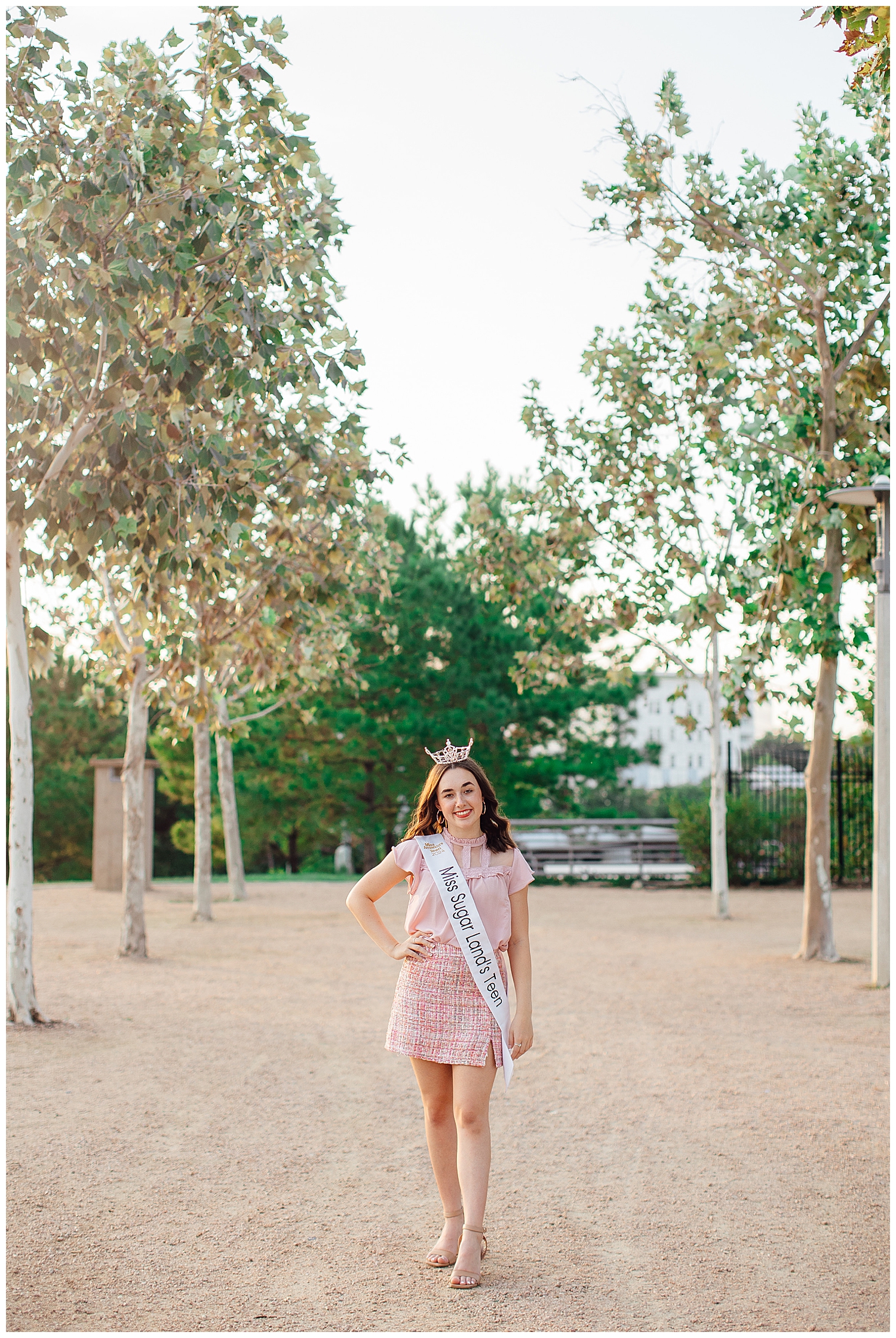 MIss Sugar Land Teen wearing crown and banner in pink skirt and shirt walking for Houston Skyline Senior Photos